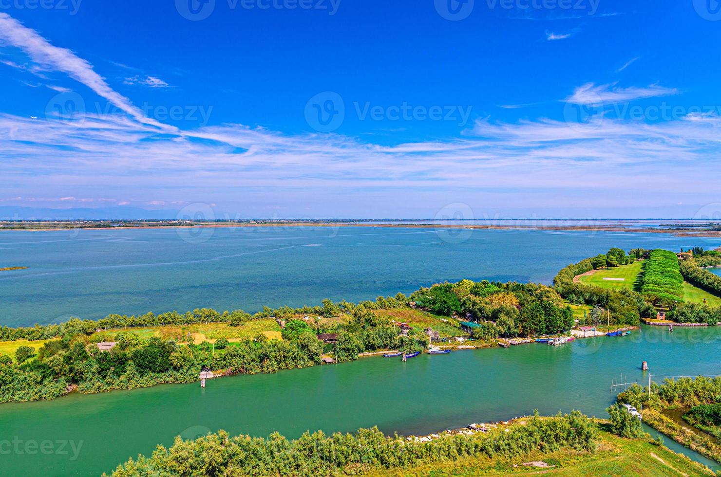 Aerial view of Torcello islands, water canal with fishing boats and green trees photo