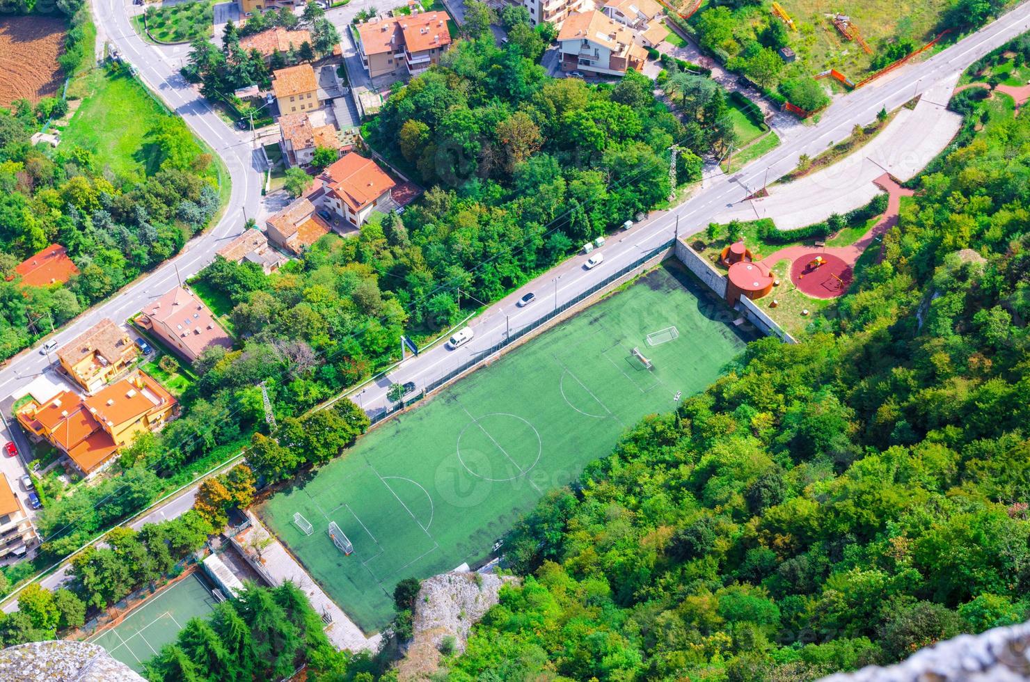 Top view from above of football stadium green grass lawn field and trees photo