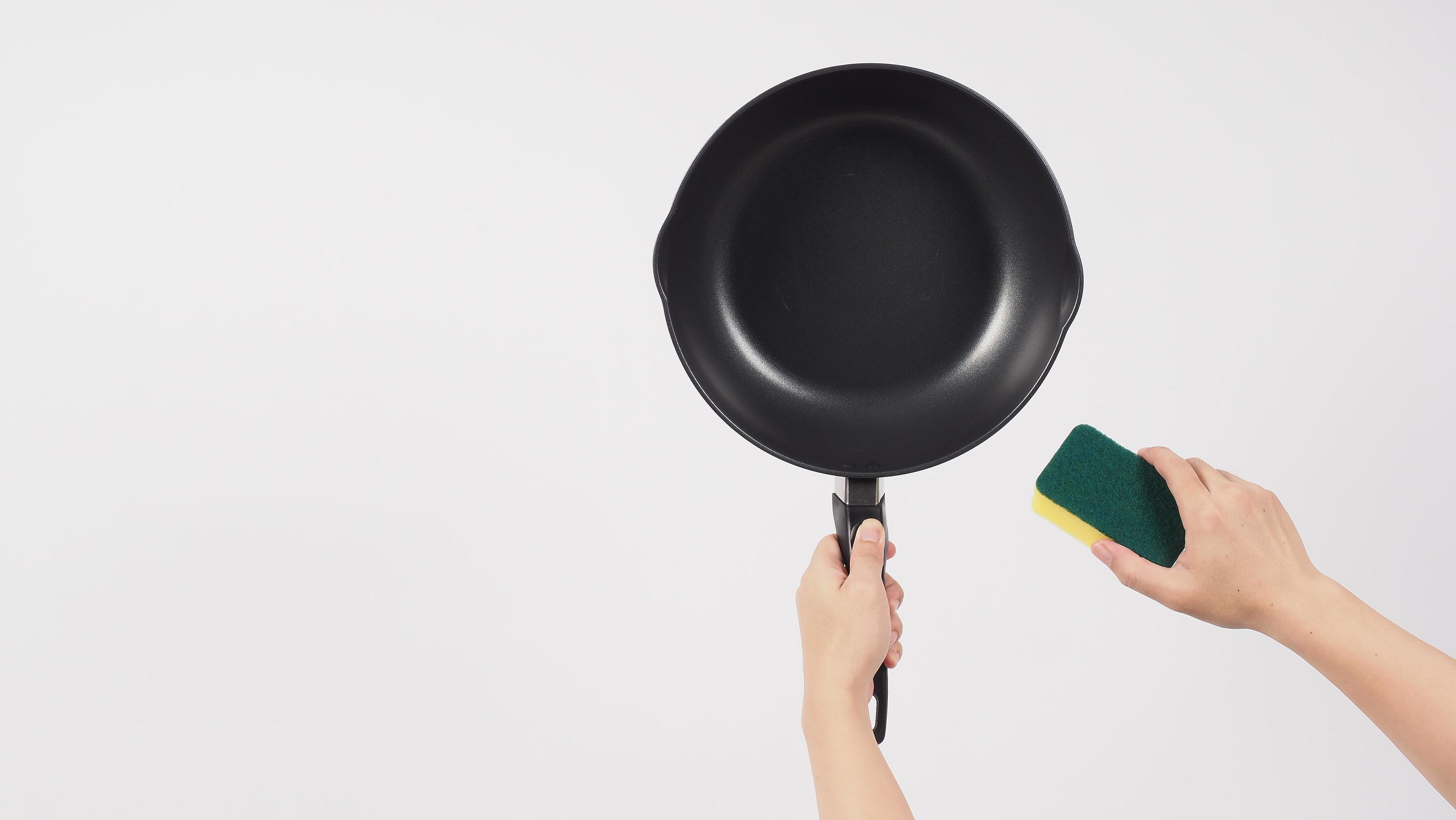 Hand cleaning the non stick pan with handy dish washing sponge 6122642  Stock Photo at Vecteezy