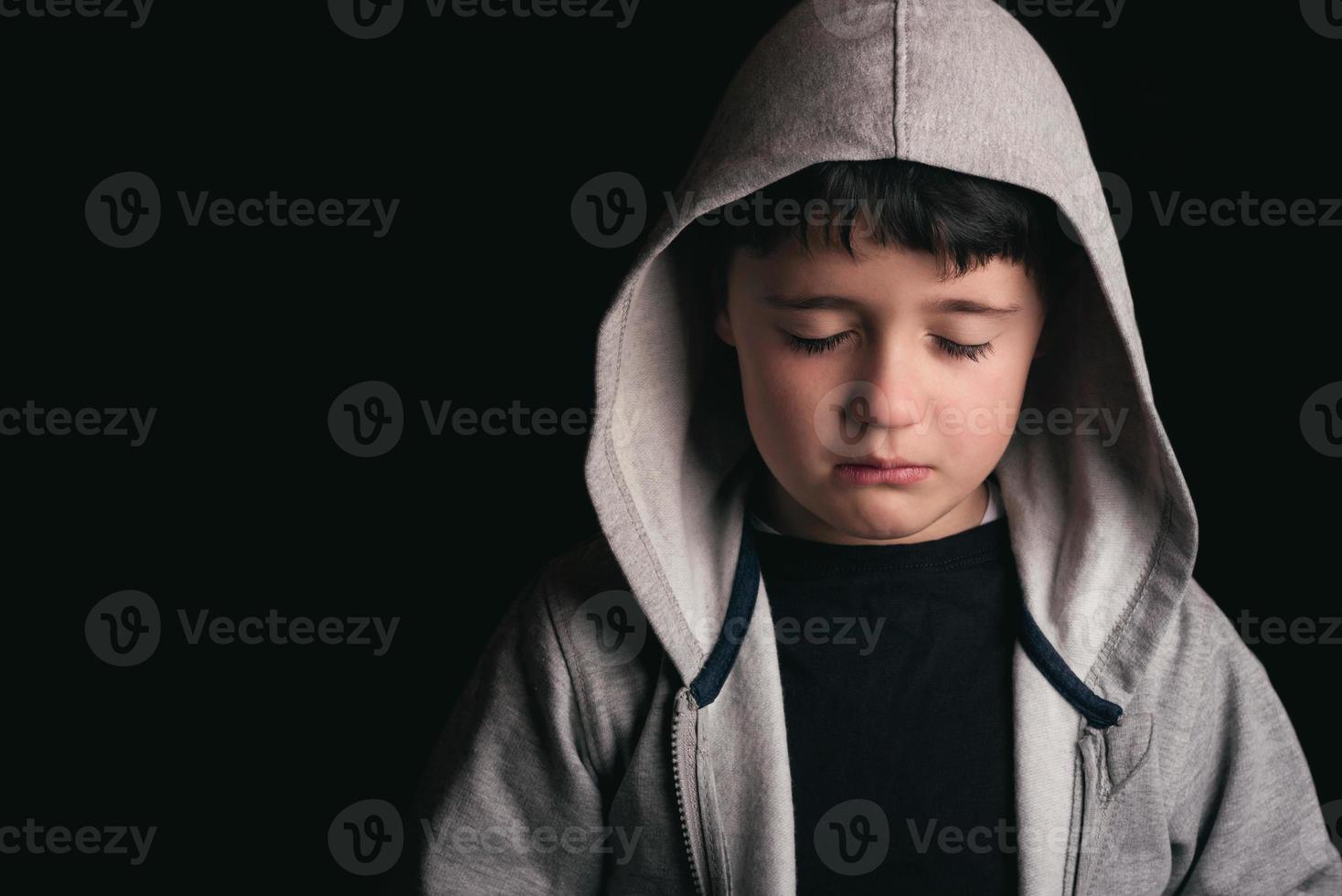 Sad boy on black background photo