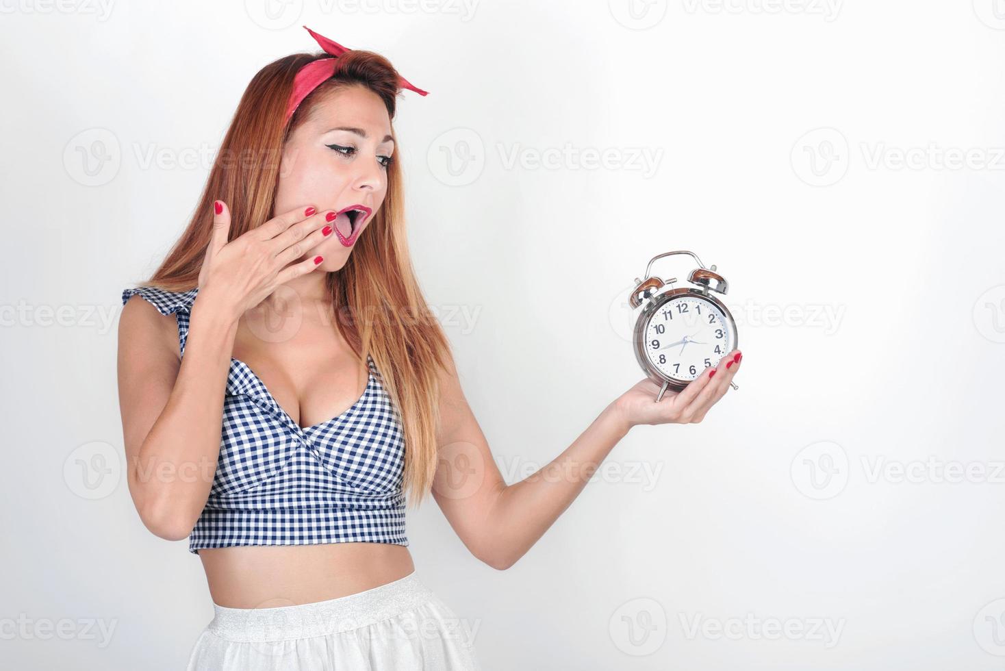 surprised  Young womanl with an alarm clock photo