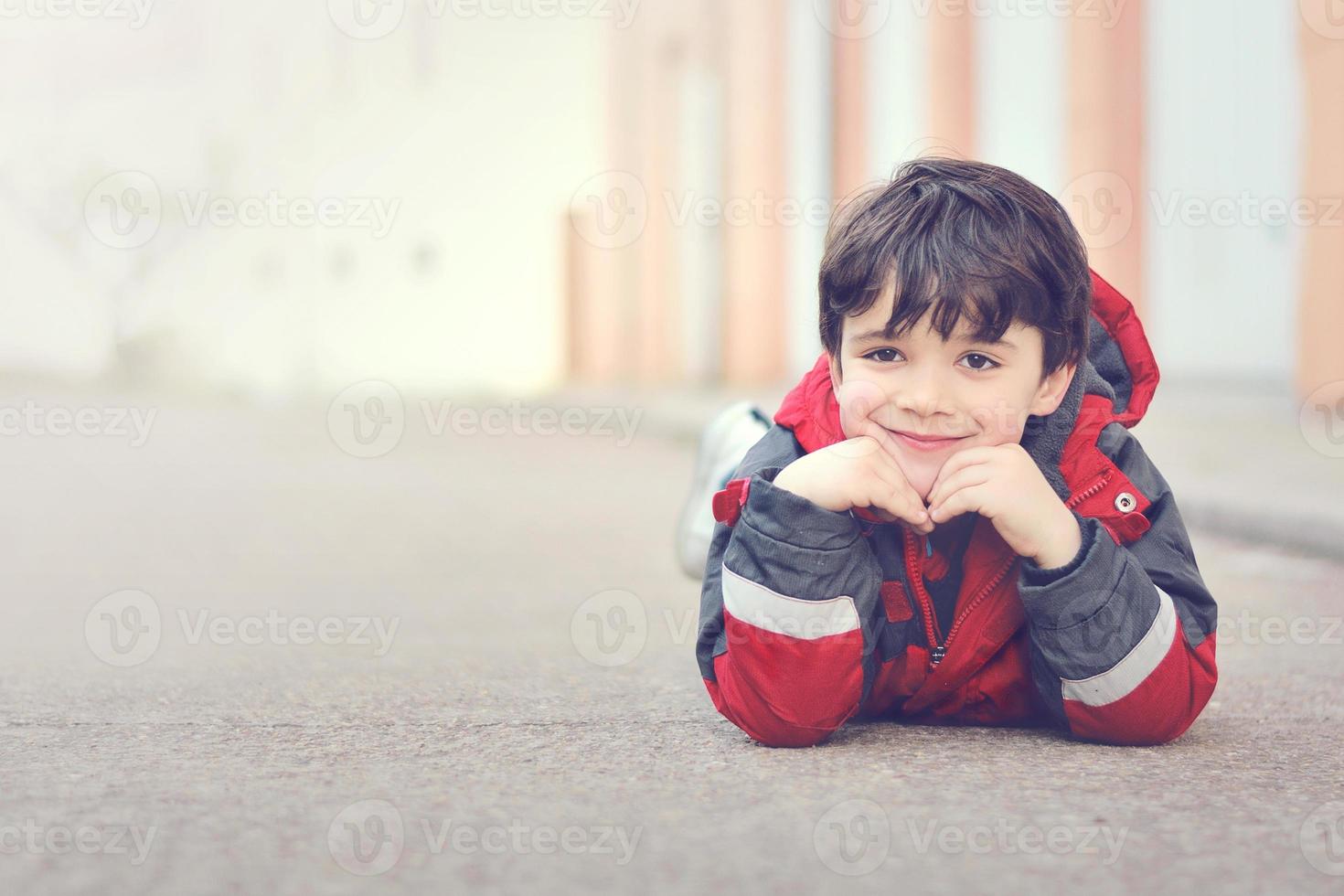 niño feliz sentado en el suelo foto