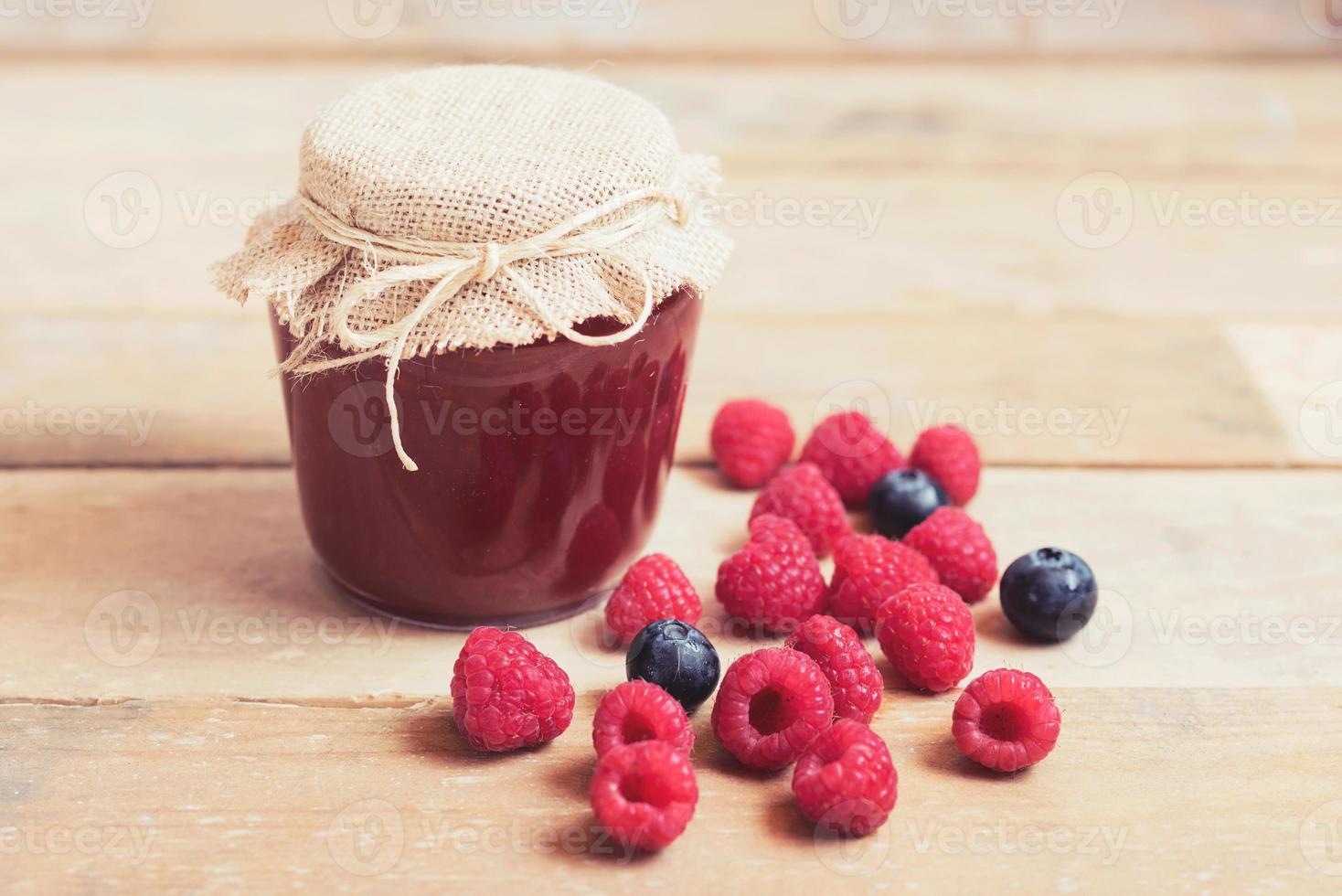 mermelada de frambuesa en una mesa de madera foto