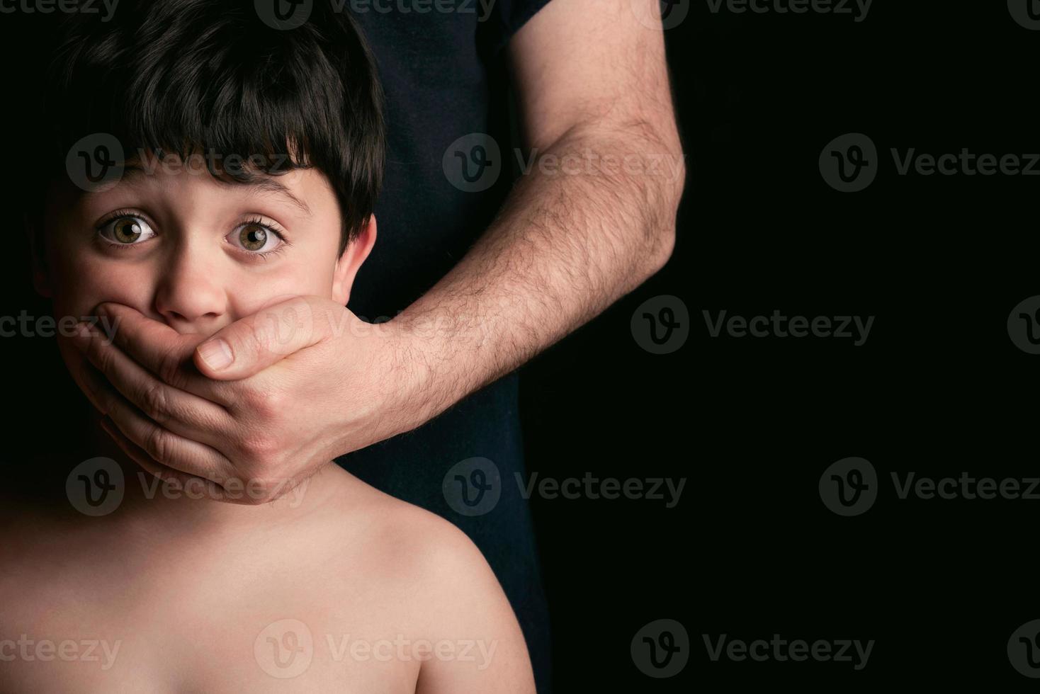 Abused child on black background photo