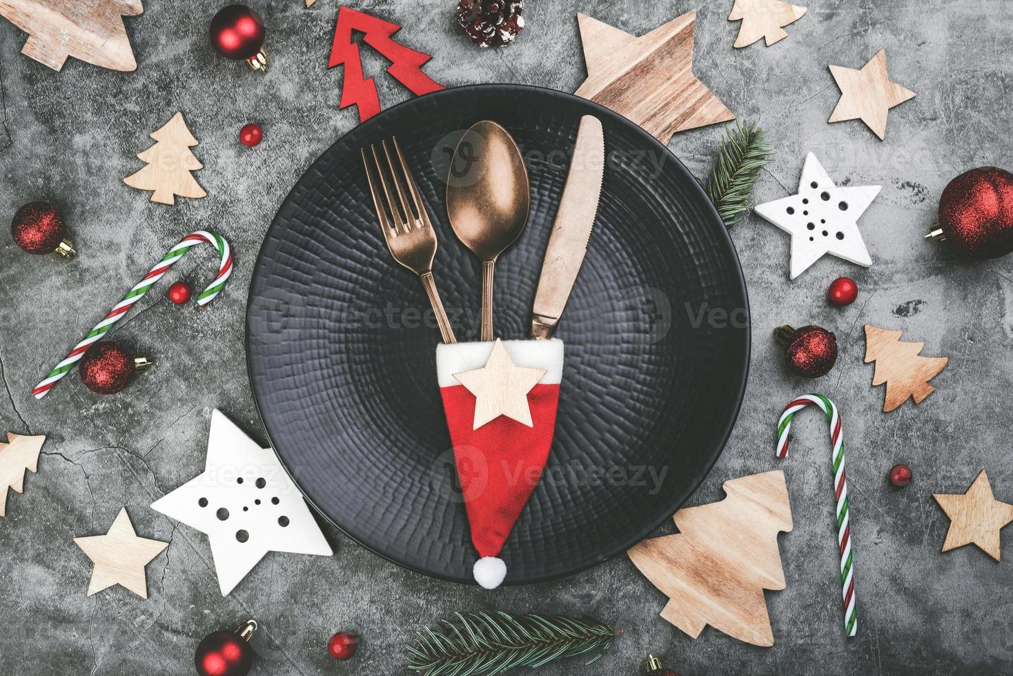 Christmas concept background.Vintage old cutlery with Santa claus hat served on plate for Christmas Dinner photo