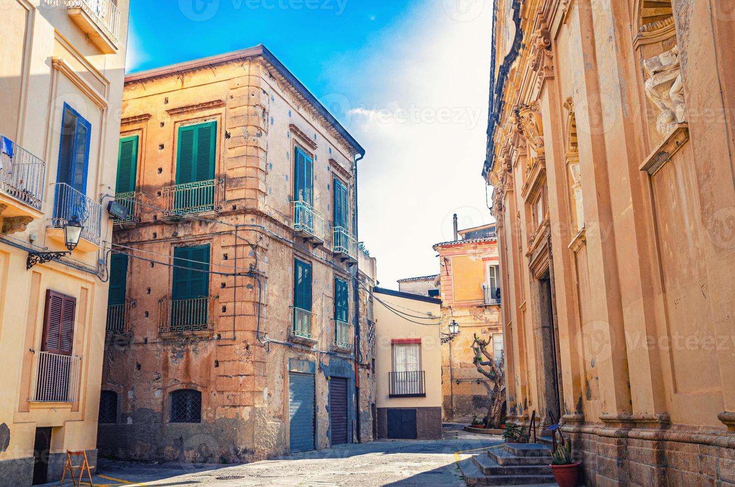 típica calle estrecha italiana del centro histórico de la ciudad de tropea con edificios antiguos foto