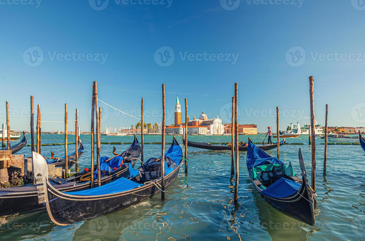 Gondolas moored docked on water in Venice photo