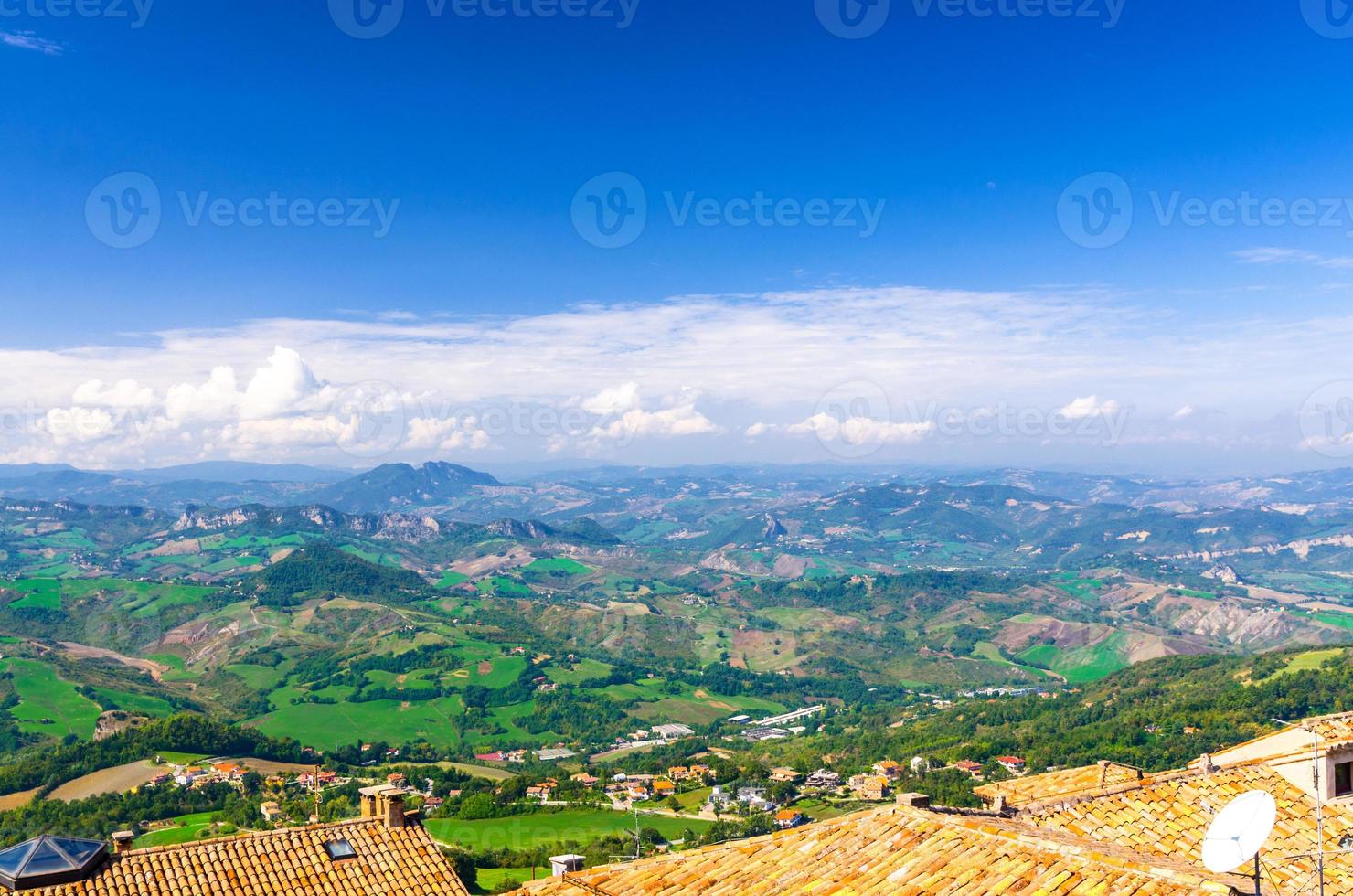 Aerial top panoramic view of landscape with valley, green hills, fields and villages of Republic San Marino photo