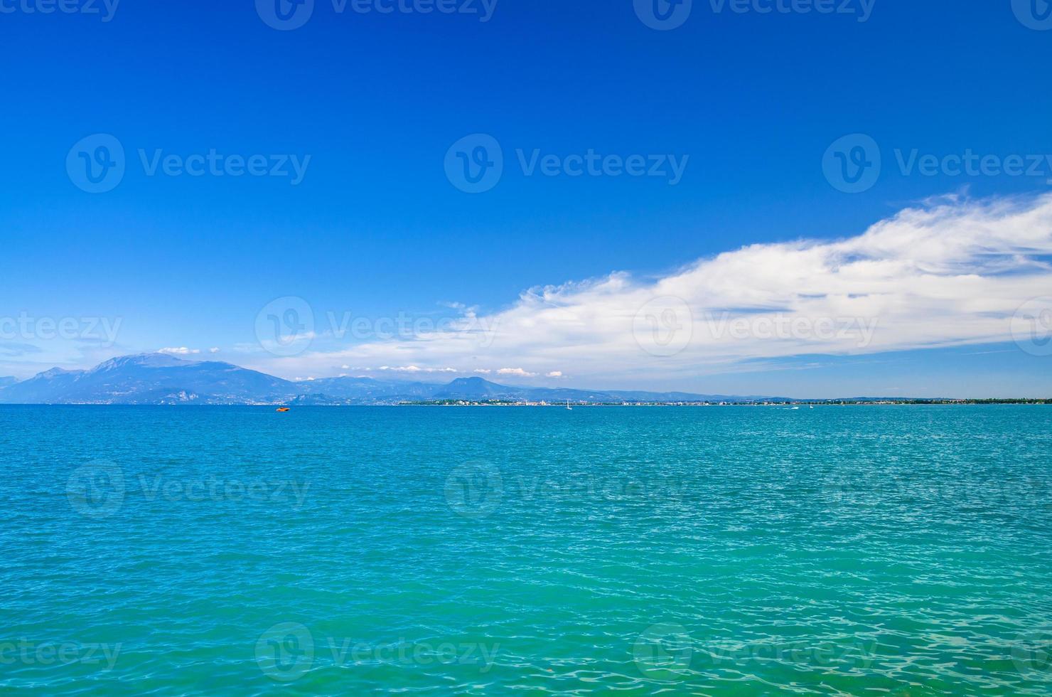 Garda Lake azure turquoise water surface with view of Monte Baldo mountain range photo