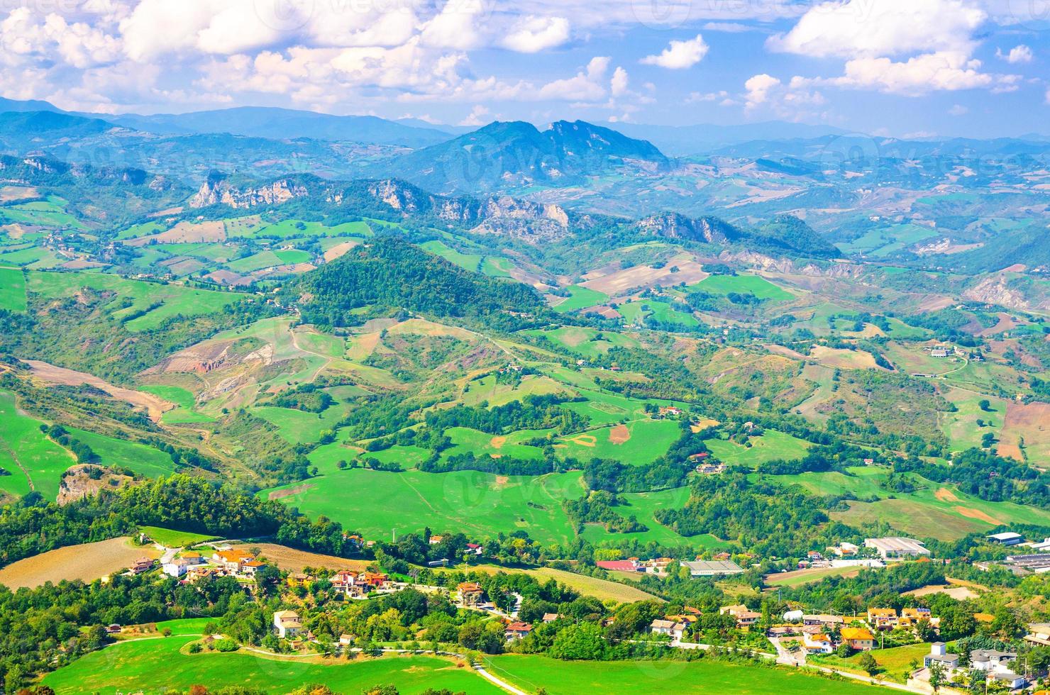Aerial top panoramic view of landscape with valley, green hills, fields and villages of Republic San Marino photo