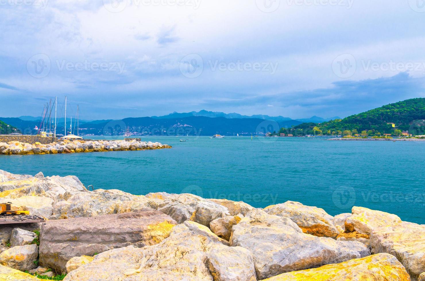 Gulf of Spezia turquoise water from Portovenere coastal town, stone coast foreground photo