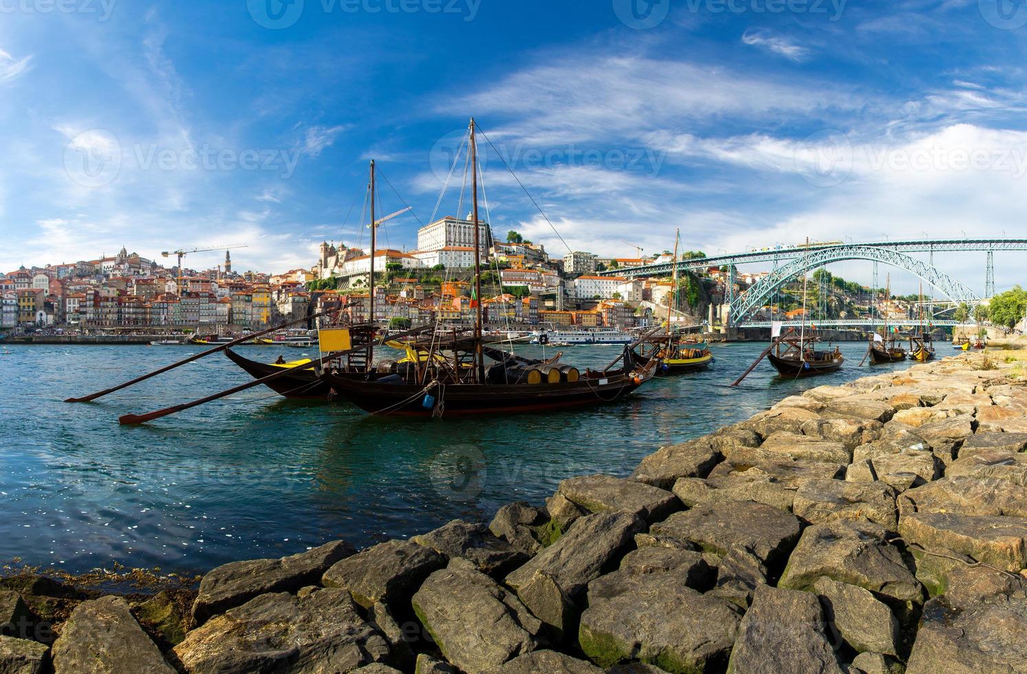 portugal, paisaje de la ciudad de porto, un grupo de botes de madera amarillos con barriles de vino en el río douro foto