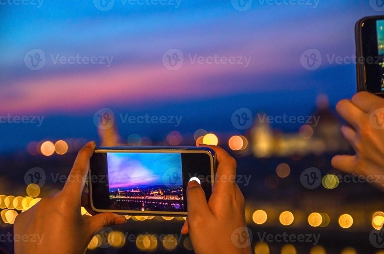Top aerial panoramic evening view of Florence city with Duomo through screen of mobile phone photo