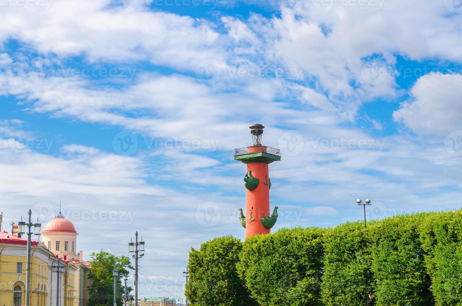 Rostral Column on Strelka Arrow of Vasilyevsky Island with green trees in Saint Petersburg photo