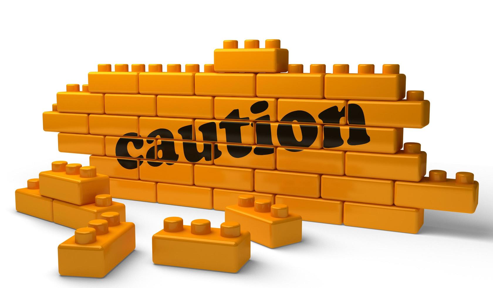 caution word on yellow brick wall photo