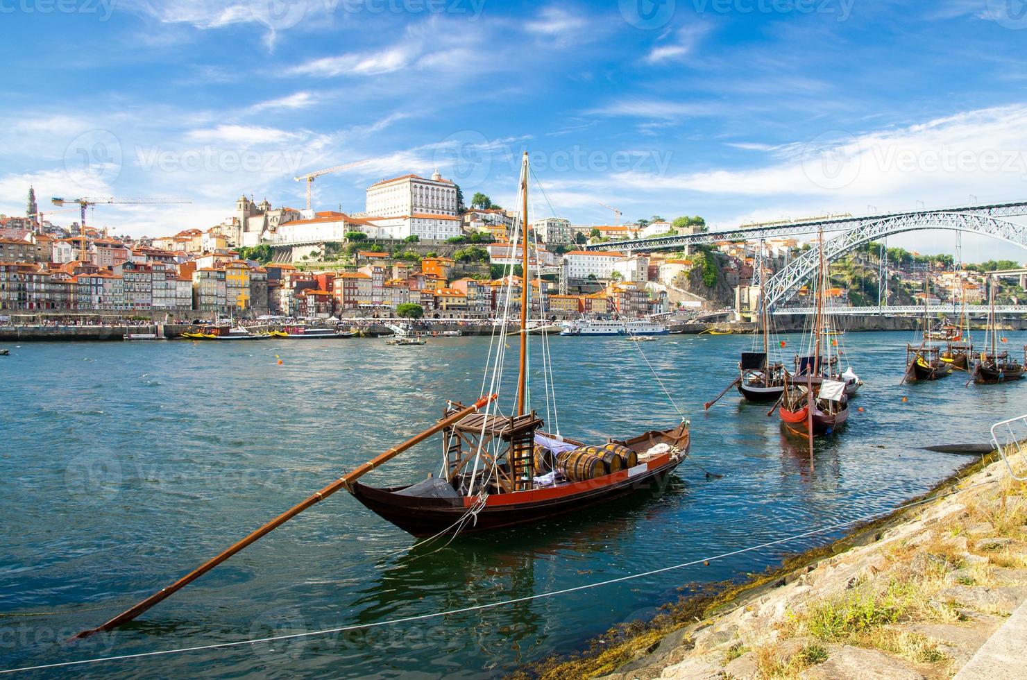 portugal, paisaje de la ciudad de porto, un grupo de botes de madera amarillos con barriles de vino en el río douro foto