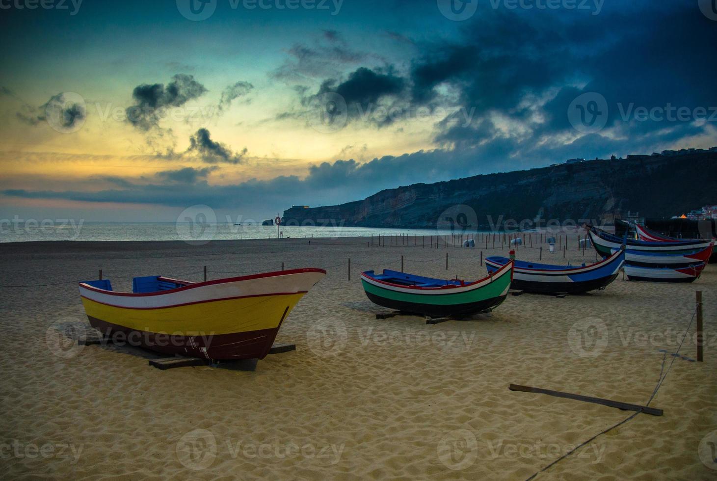 Portugal, Nazare beach, colored wooden boats, panoramic view of Nazare Town, Traditional Portuguese fishing boats photo