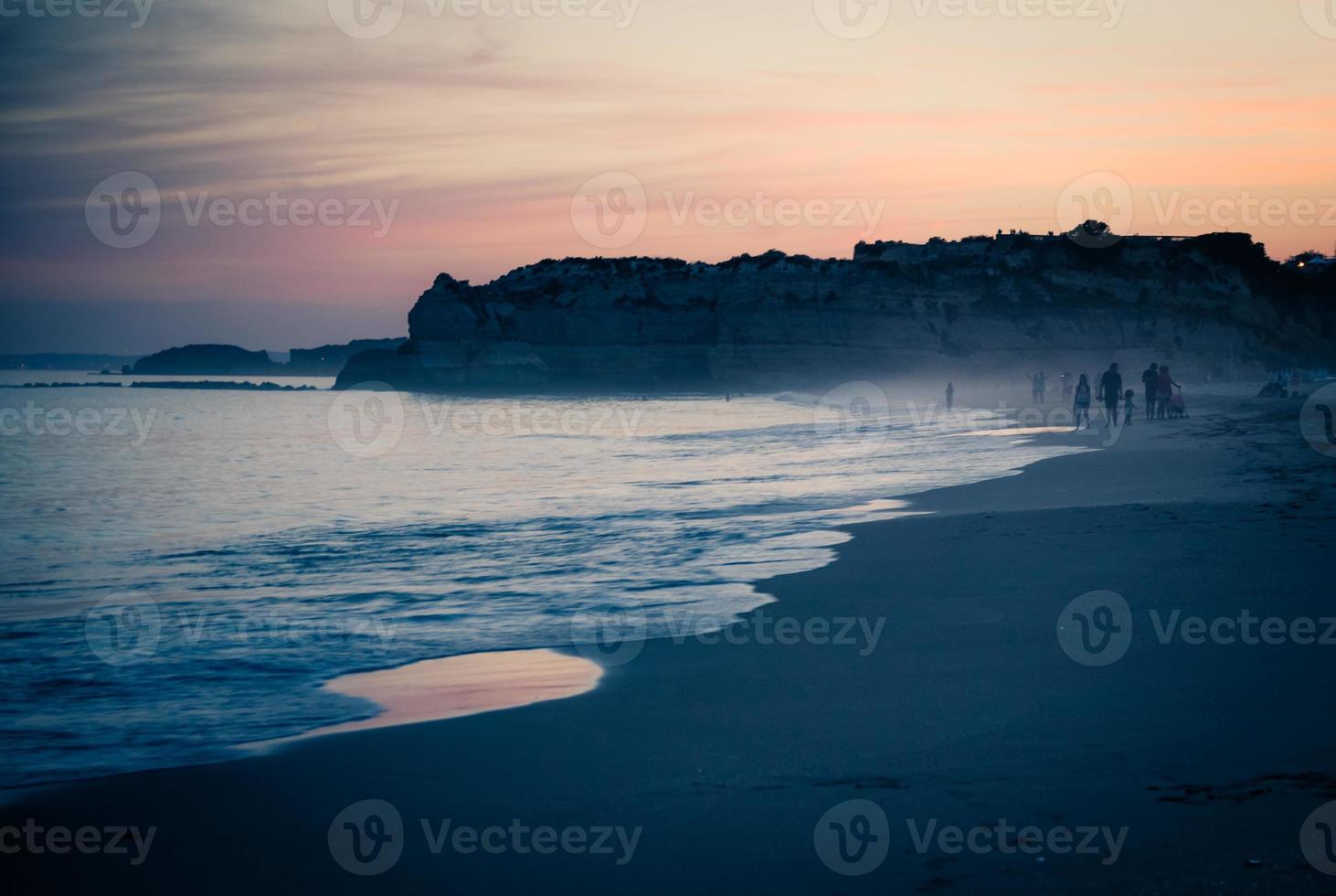 Portugal, Algarve, The best beaches of Portimao, Praia da Rocha, lilac golden sunset over the waves of The Atlantic Ocean photo