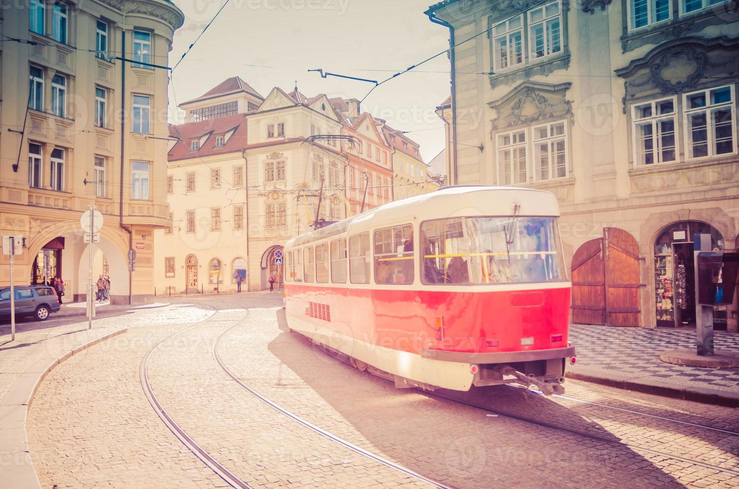 Typical old retro vintage tram on tracks near tram stop in the streets of Prague city photo