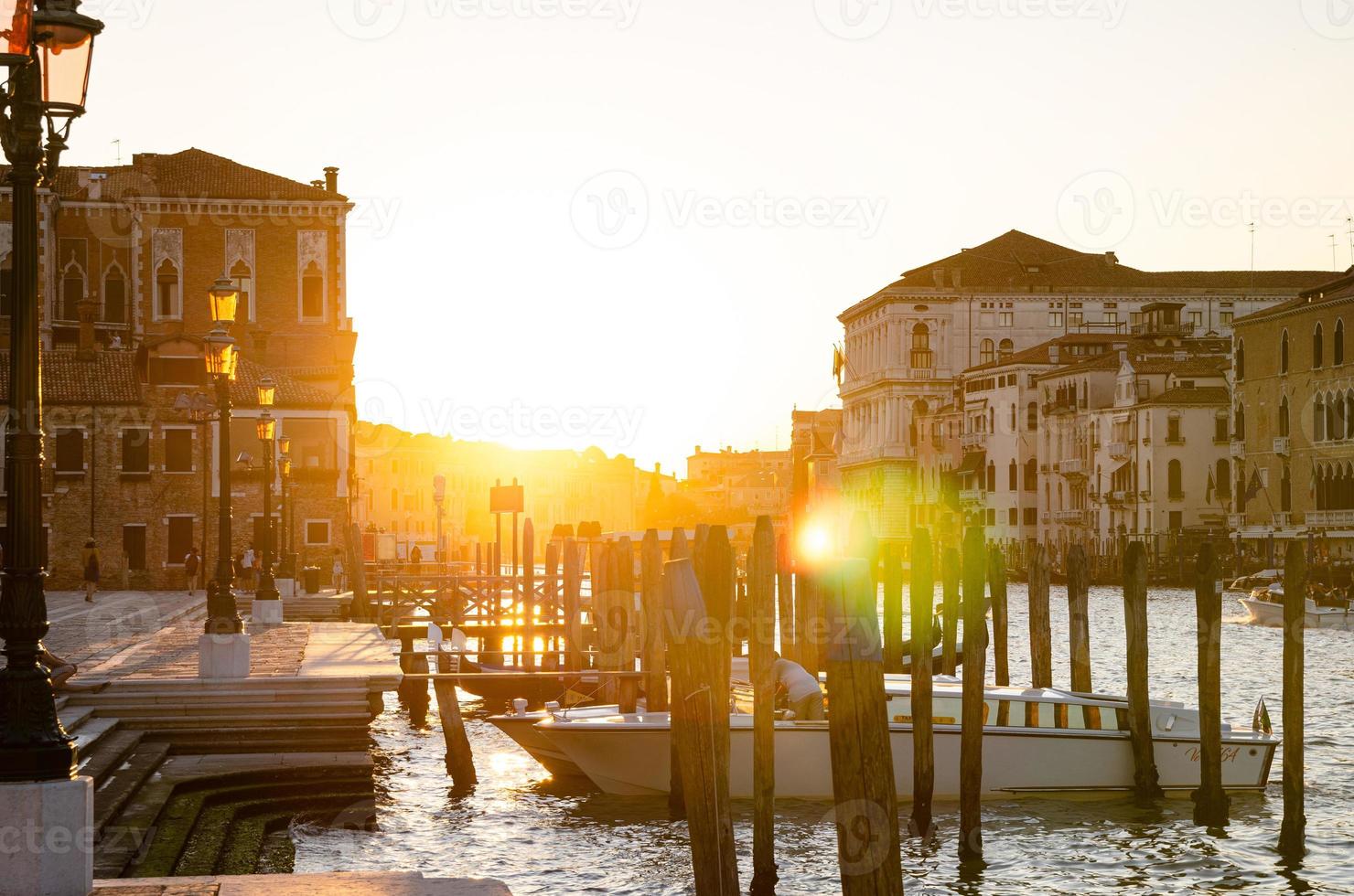 Yacht boat moored docked on pier of Grand Canal water in Venice city, street lights on embankment photo