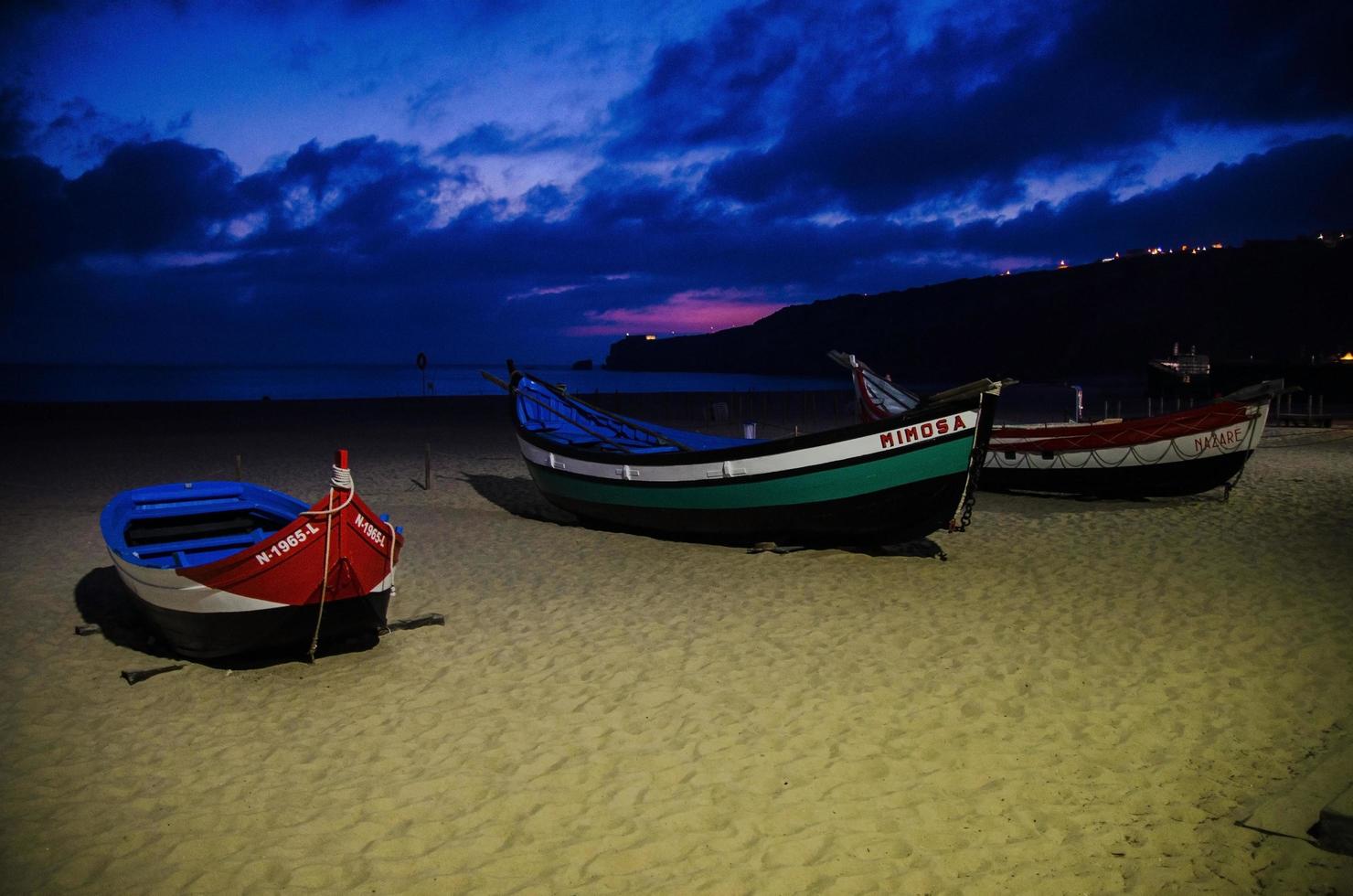 Traditional fishing boats on the sandy beach of Nazare photo