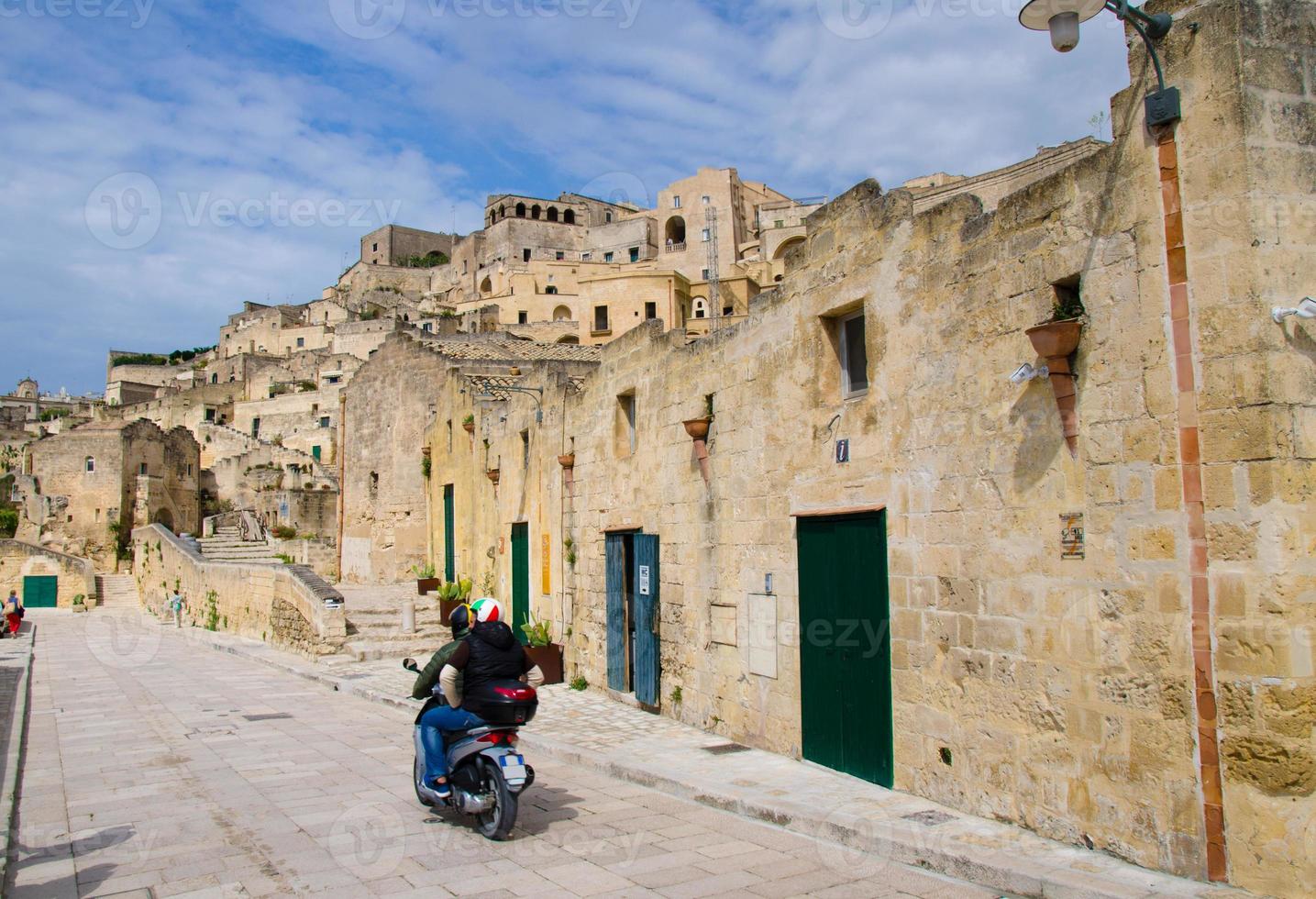 Motorcyclists in helmets riding a motorcycle on streets, Matera, Italy photo