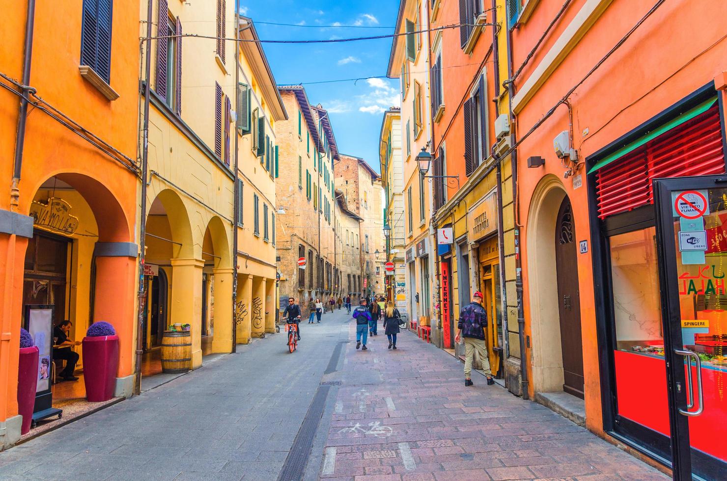 bolonia, italia, la gente camina por la típica calle italiana con edificios foto