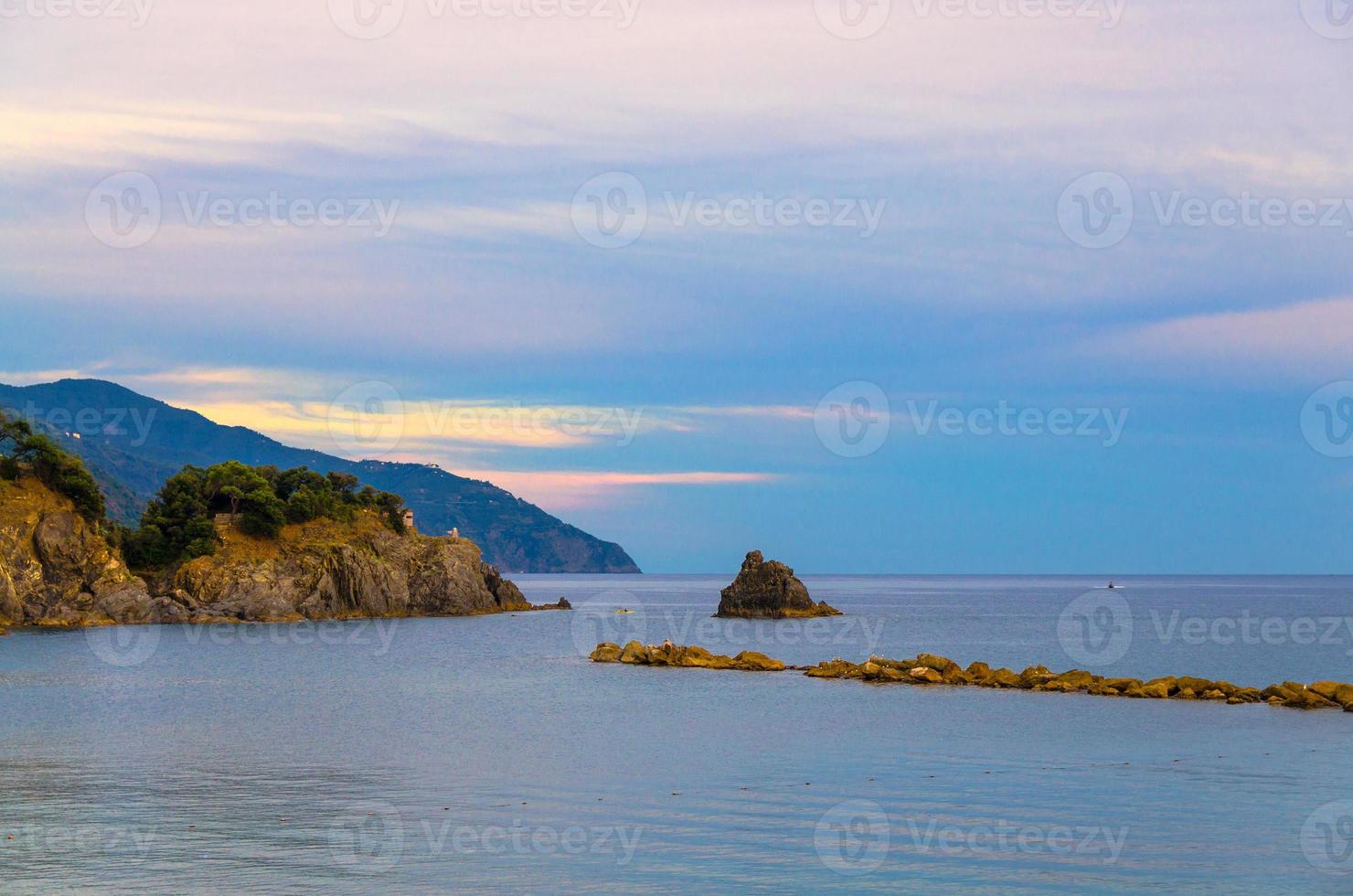 Aerial top panoramic view of green hills, rocks, cliffs and Gulf of Genoa at sunset dusk photo