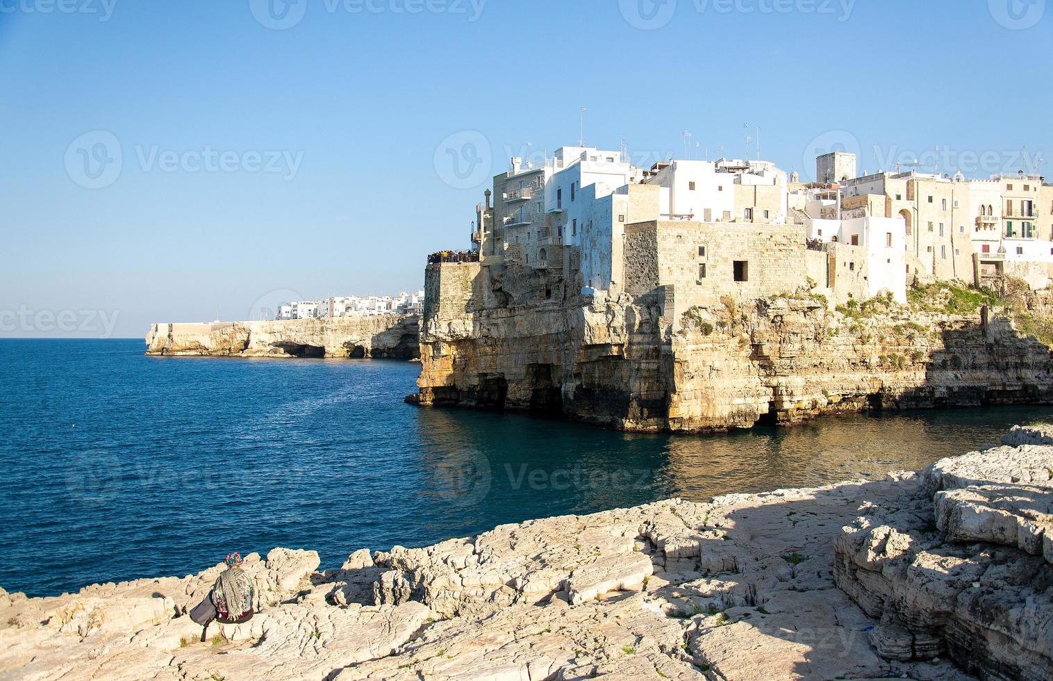 edificios blancos en grutas y acantilados en la ciudad de polignano a mare en puglia foto