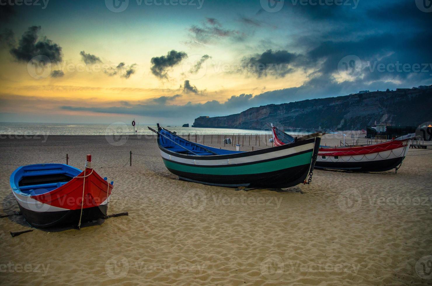 Portugal, Nazare beach, colored wooden boats, panoramic view of Nazare Town, Traditional Portuguese fishing boats photo