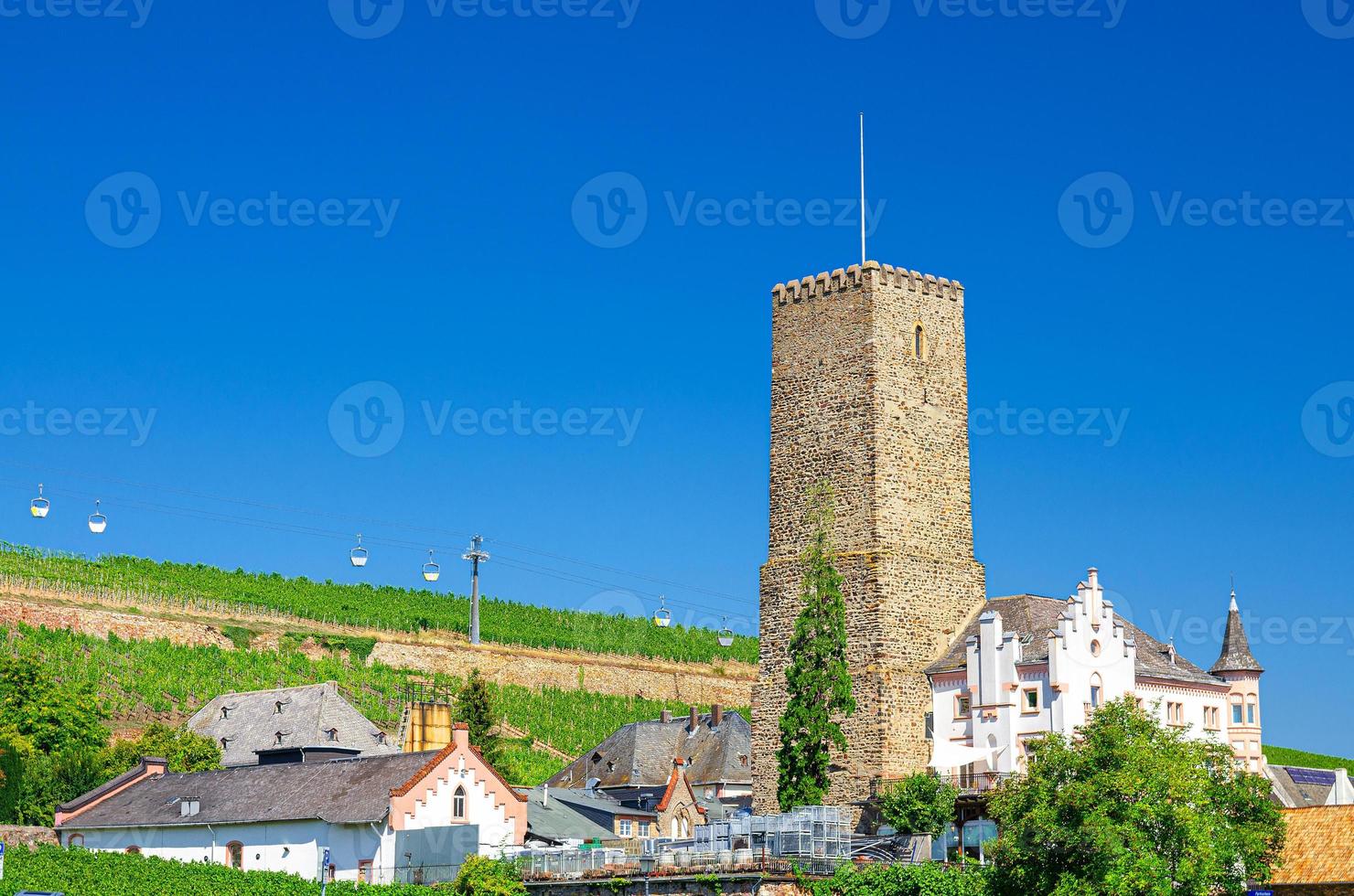 edificio de la torre de piedra, teleférico por encima de los campos de viñedos de las colinas del valle del río Rin en rudesheim am rhein foto