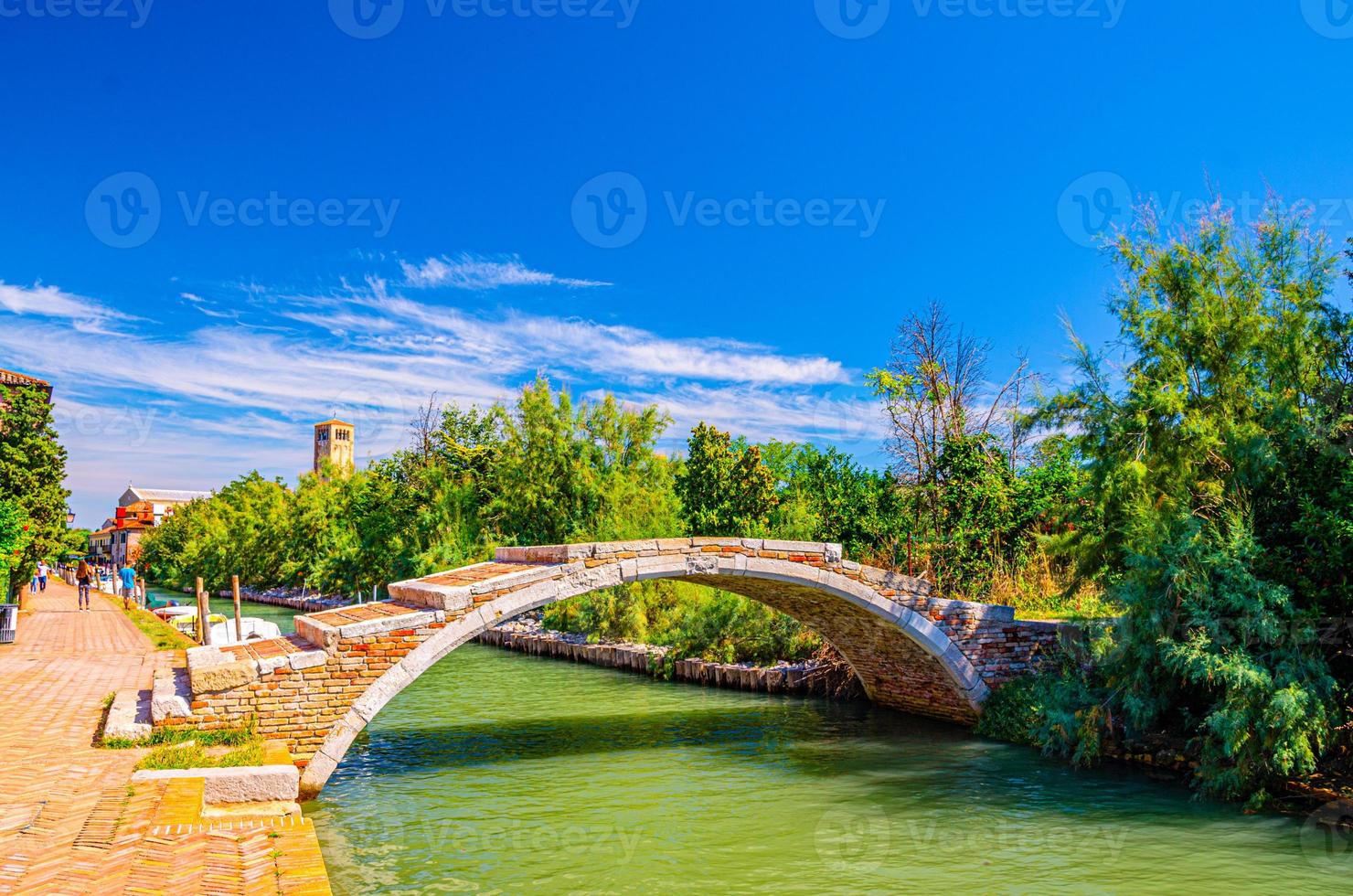 puente de piedra del diablo a través del canal de agua en la isla de torcello foto