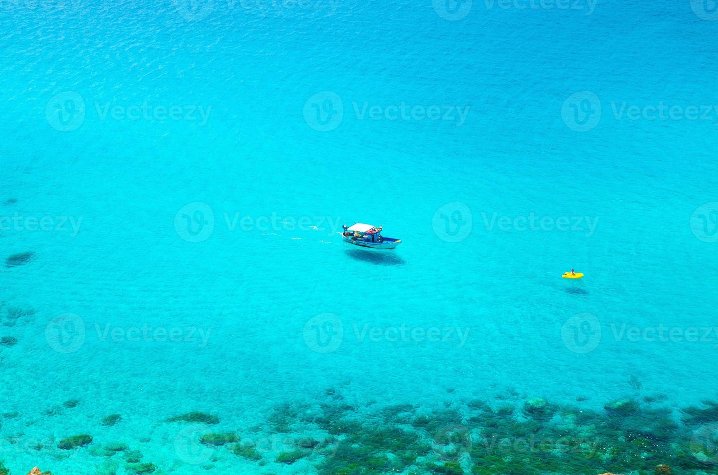 Fishing yacht and rubber boat in Capo Vaticano lagoon, Calabria, Italy photo