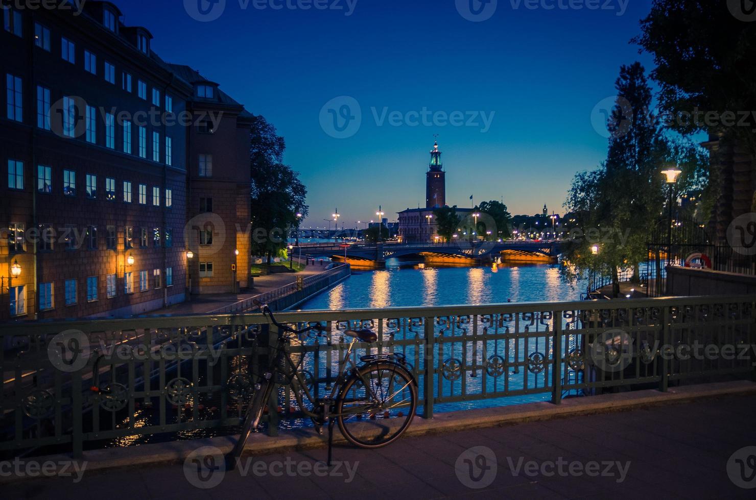 Bicicleta cerca de la barandilla del puente y el ayuntamiento de Estocolmo Stadshuset, Suecia foto