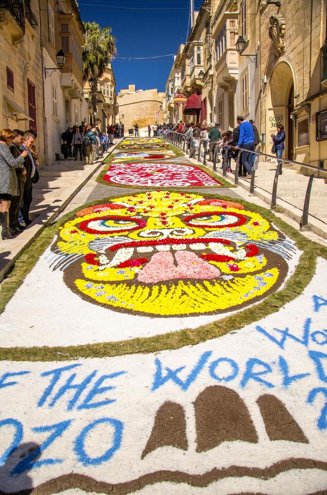 Colorful mosaic flowers drawing carpet on street near the old medieval Cittadella tower castle photo