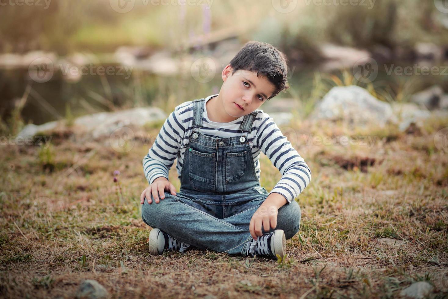 Sad boy sitting in the field photo