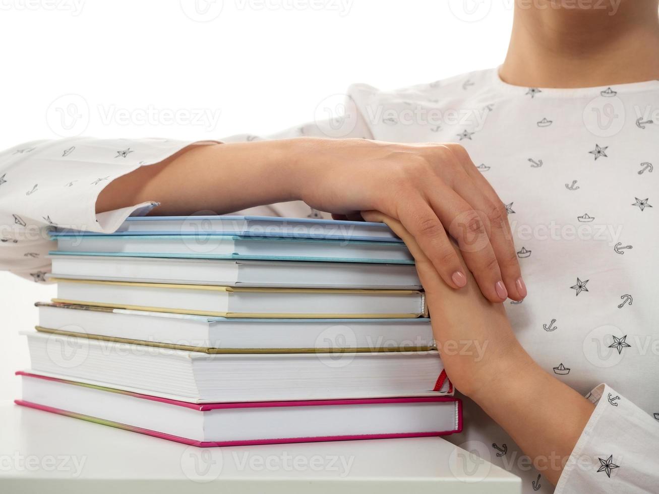 pila de libros con las manos en él foto