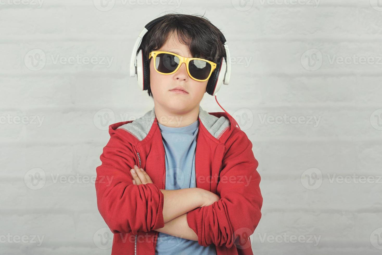 serious child with sunglasses and headphones photo