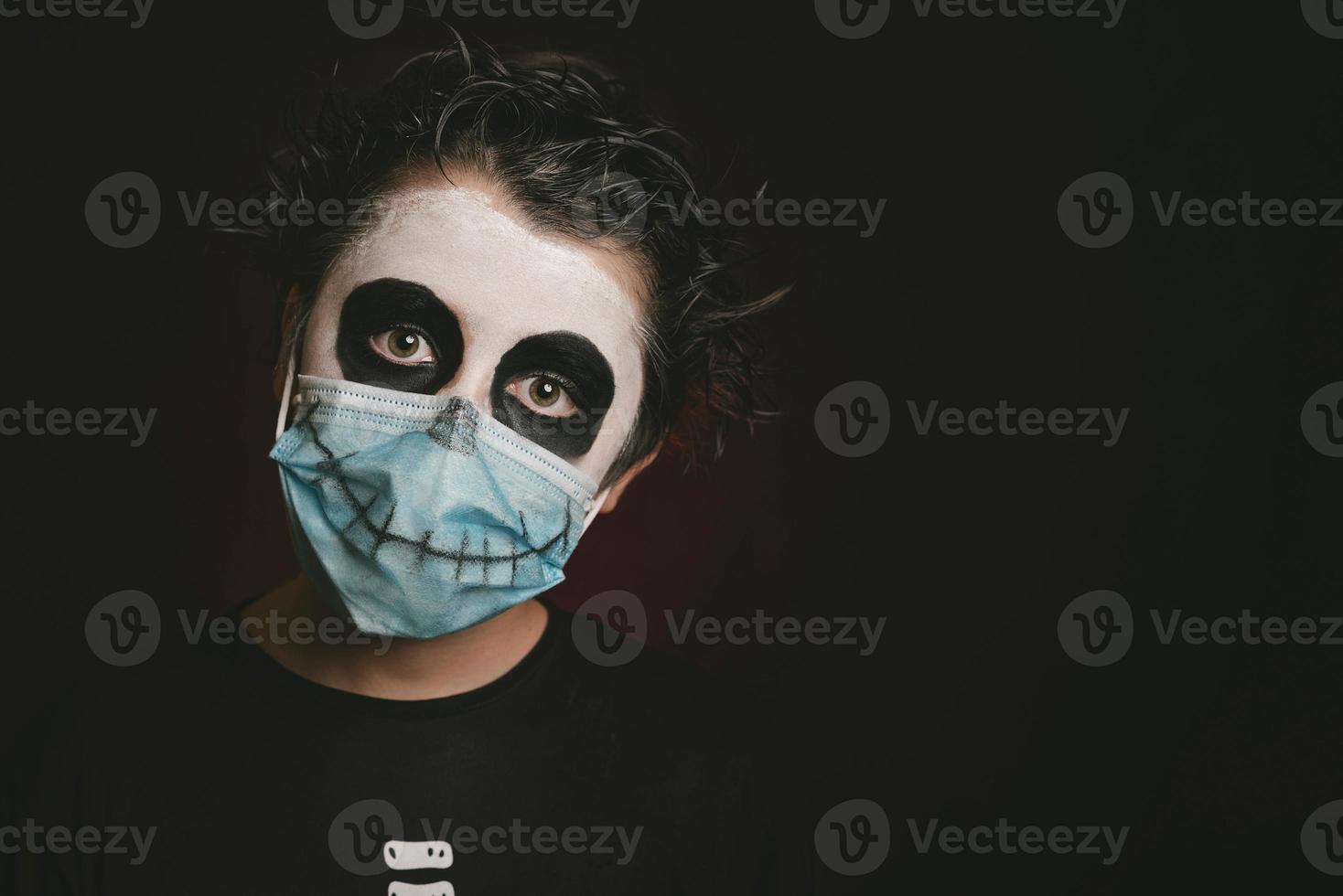 Happy Halloween.Close-up of kid wearing medical mask in a skeleton costume photo