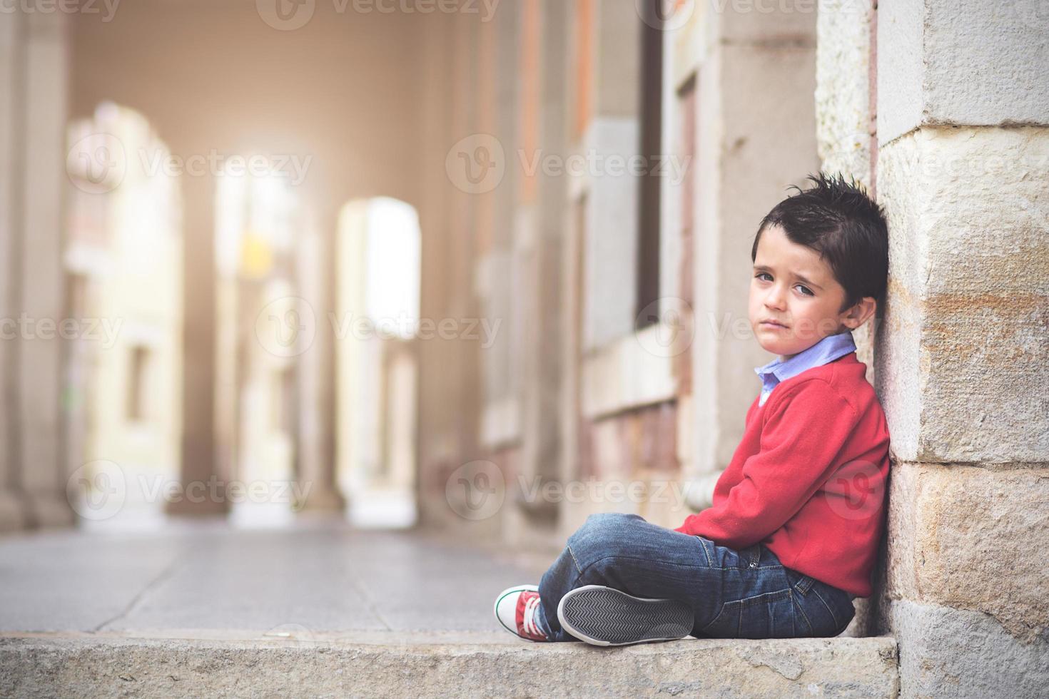 Sad boy sitting on the floor photo