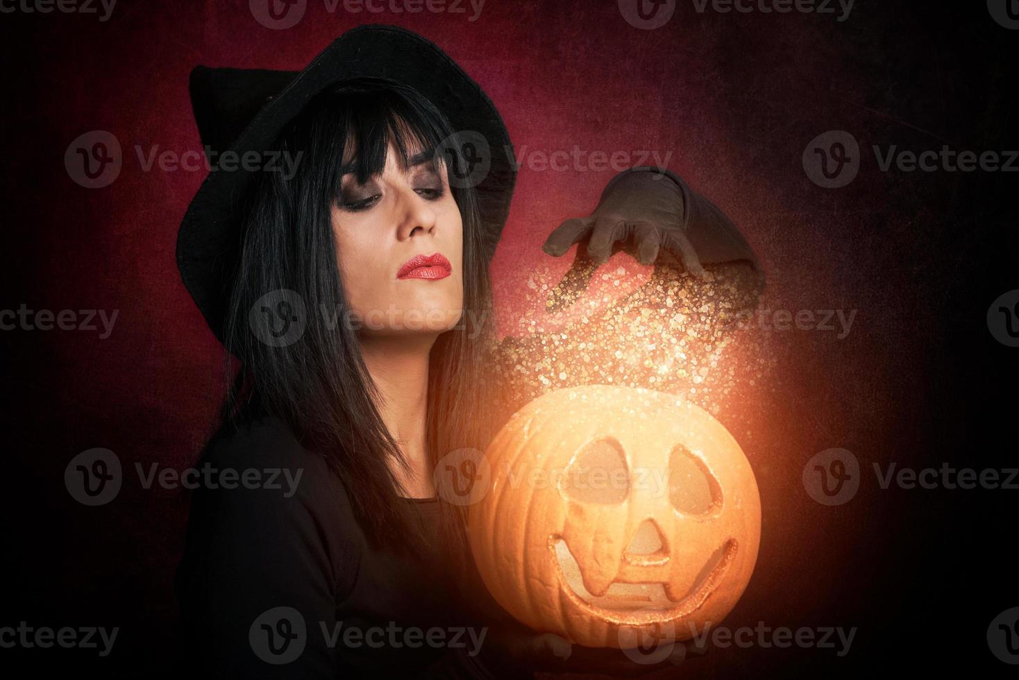 hermosa joven como bruja con calabaza foto