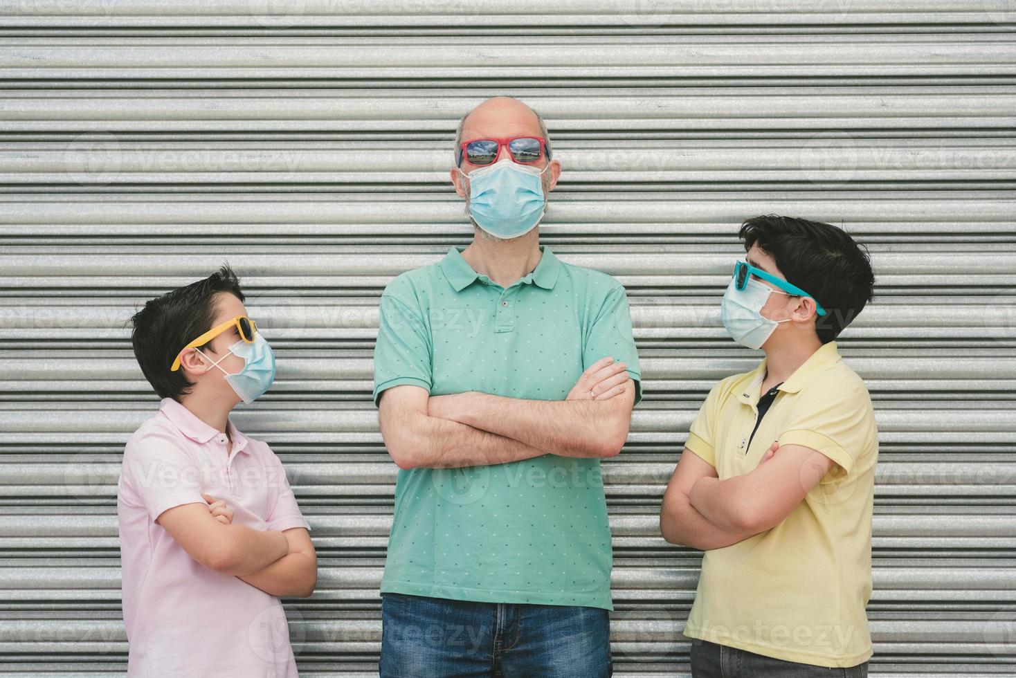 father with his sons wearing medical mask and sunglasses photo