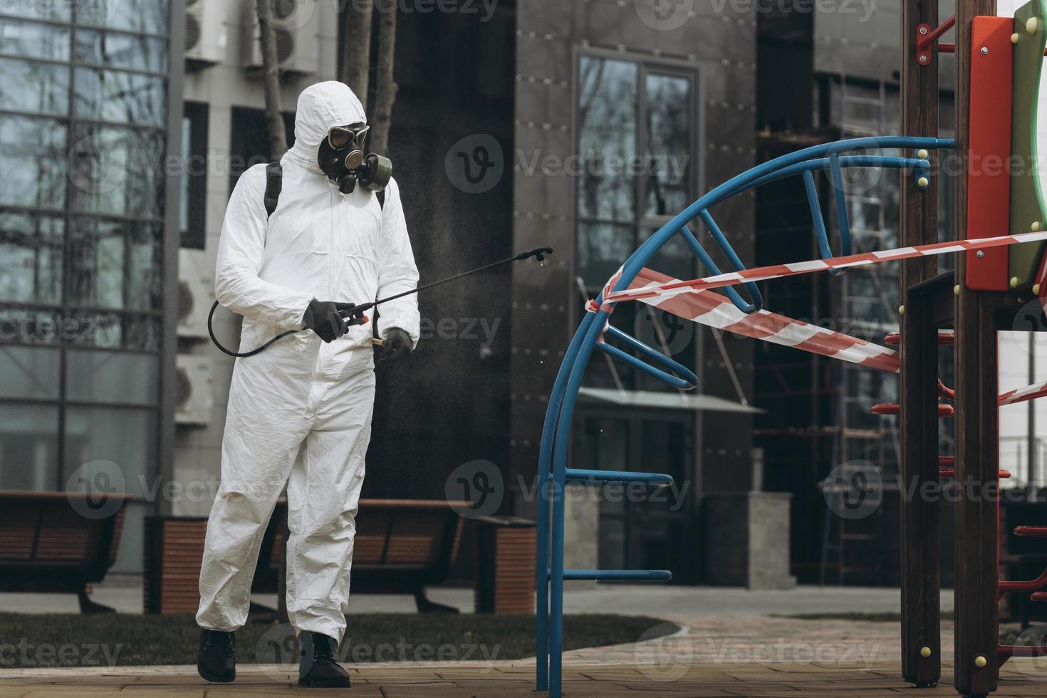 Cleaning and Disinfection on the playground in the sity complex amid the coronavirus epidemic Teams for disinfection efforts Infection prevention and control of epidemic Protective suit and mask photo