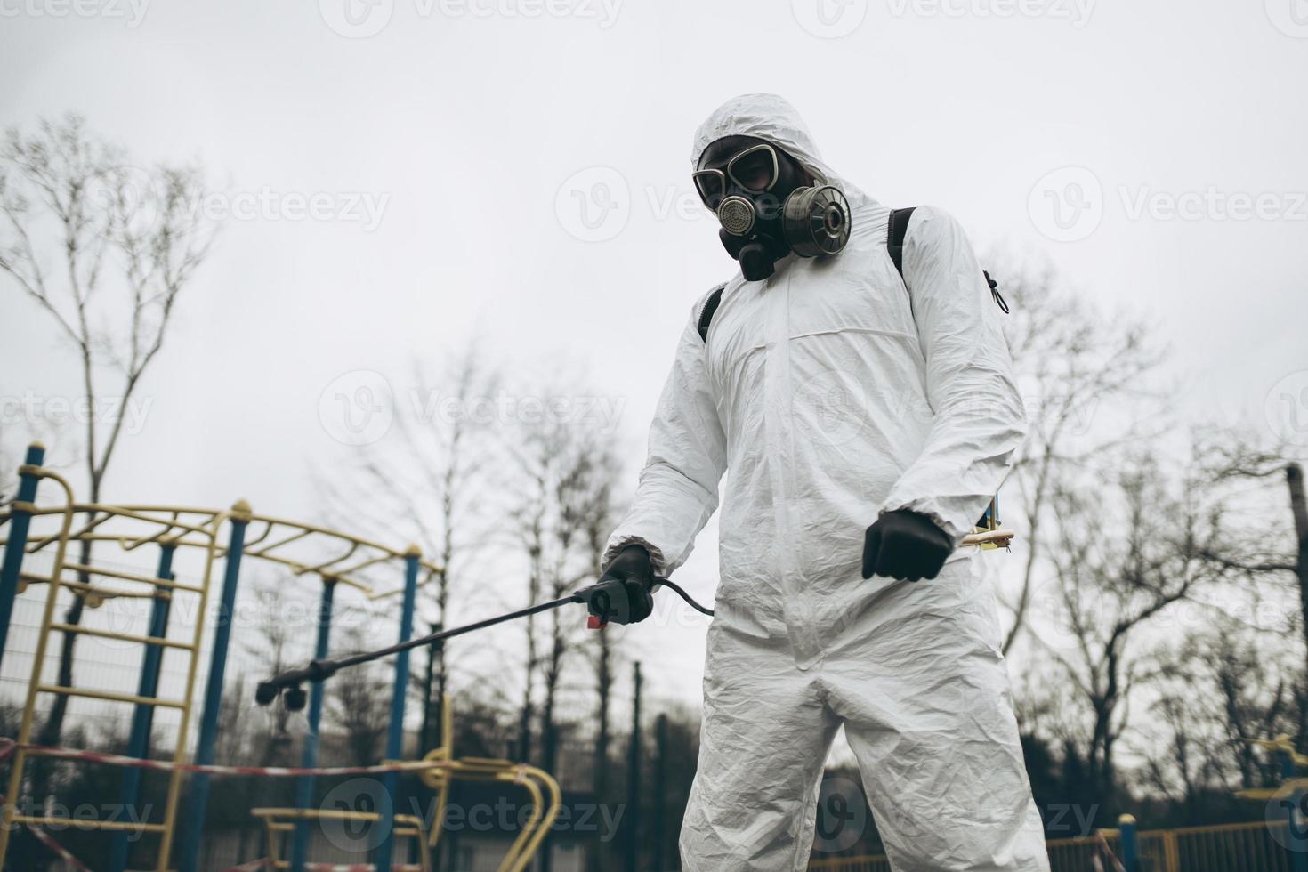 Cleaning and Disinfection on the playground in the sity complex amid the coronavirus epidemic Teams for disinfection efforts Infection prevention and control of epidemic Protective suit and mask photo