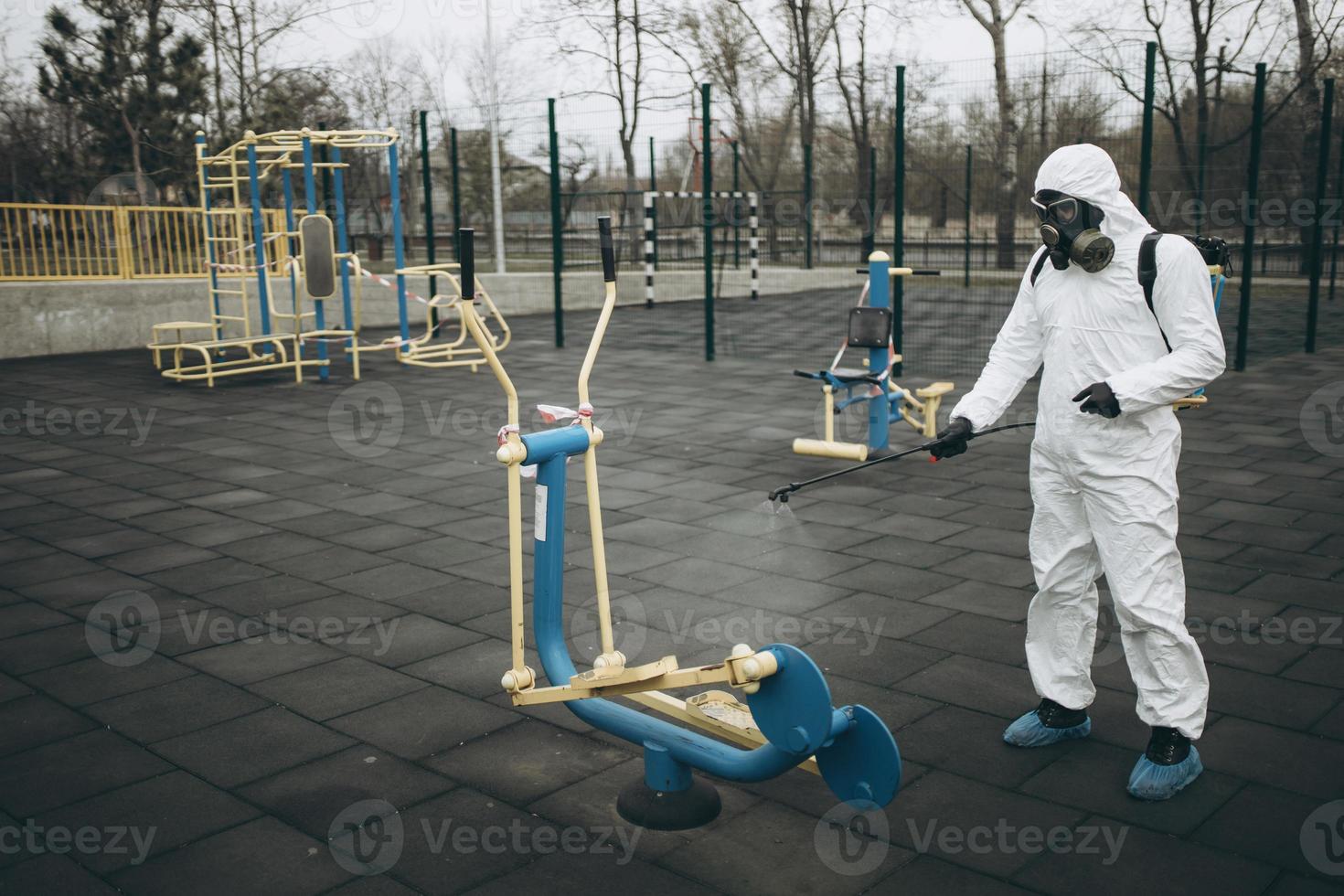 Cleaning and Disinfection on the playground in the sity complex amid the coronavirus epidemic Teams for disinfection efforts Infection prevention and control of epidemic Protective suit and mask photo