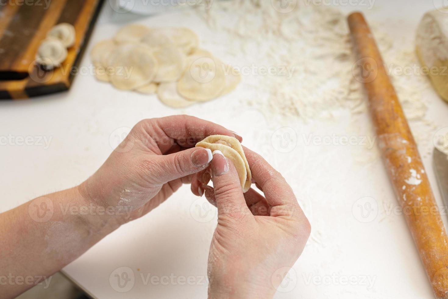 homemade dumplings in the kitchen without decorations. making dumplings with minced pork, beef and chicken photo