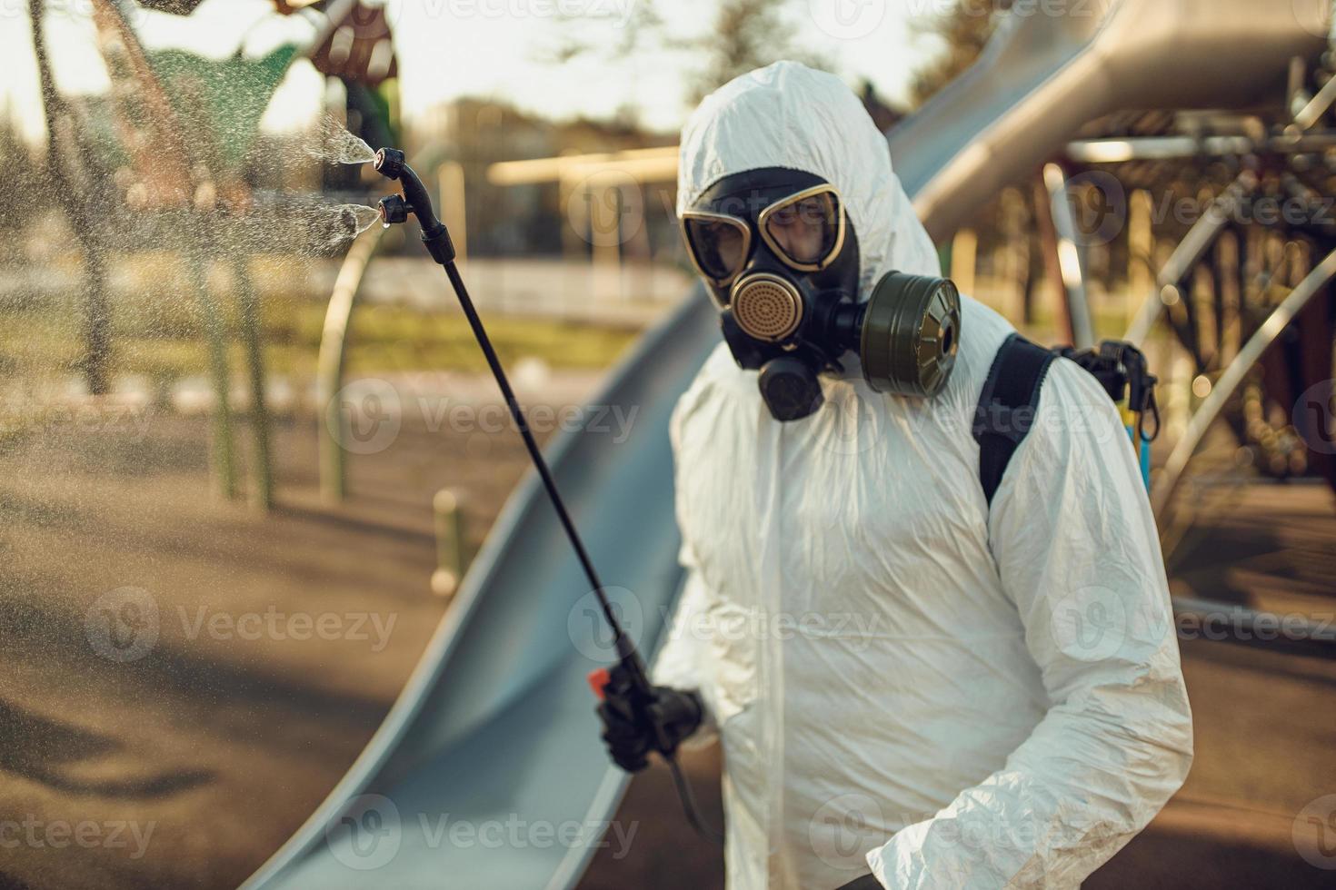 Cleaning and Disinfection on the playground in the sity complex amid the coronavirus epidemic Teams for disinfection efforts Infection prevention and control of epidemic Protective suit and mask photo