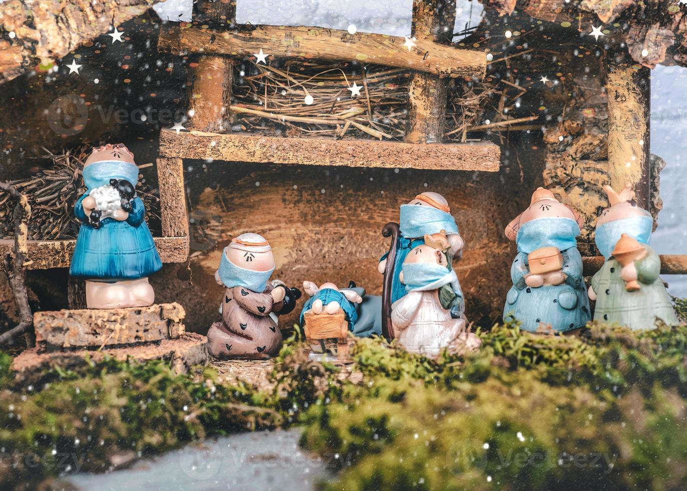 Christmas nativity scene. Nativity statues figurines with protective surgical masks.Scene of born child baby Jesus photo