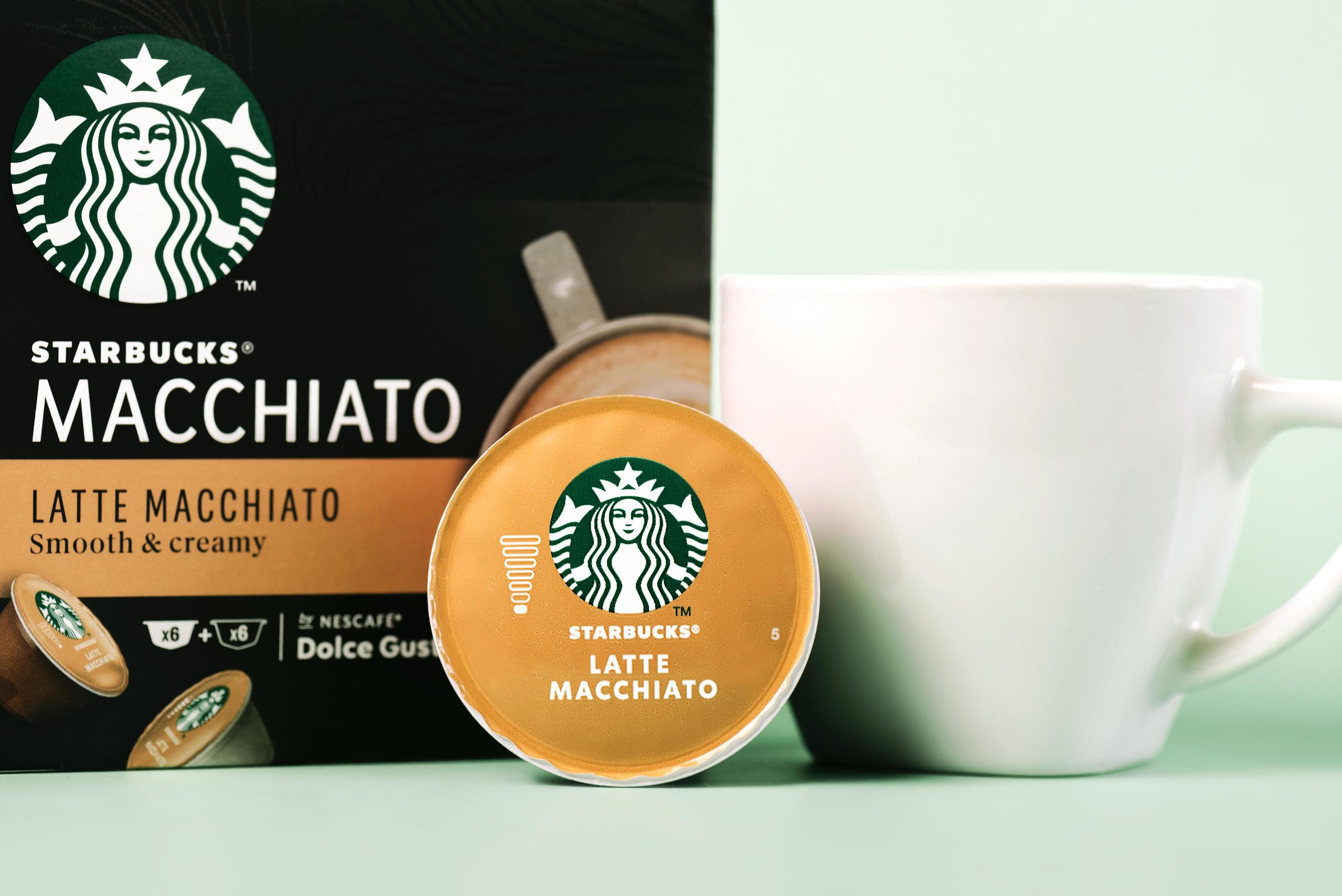 Starbucks latte Macchiato coffee capsules box next to white cup of coffee  and capsule latte macchiato 6150120 Stock Photo at Vecteezy