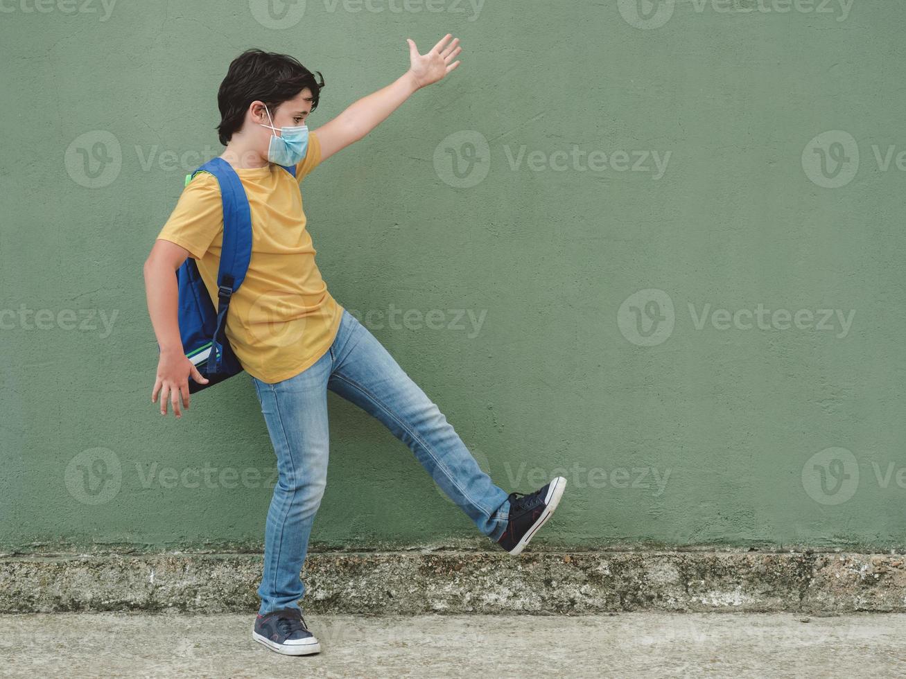 happy kid with medical mask and backpack going to school photo